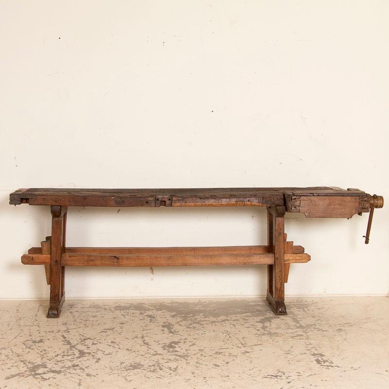 It is the years of constant use revealed in every ding and scratch that enrich the character of this carpenters' workbench from Denmark. Please examine the close up photos to appreciate the dark patina, joints and old hardware. It has one vice with