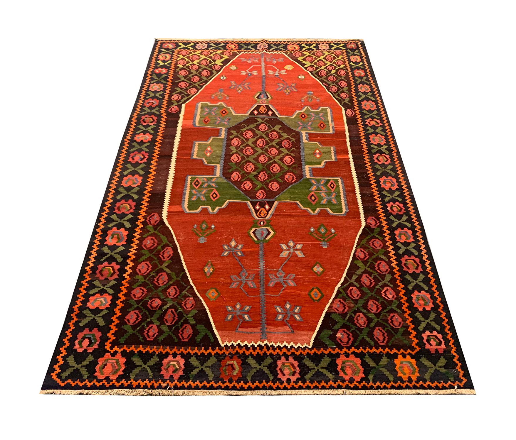 This beautiful antique Kilim is a fine example of a Caucasian Karabagh rug, woven in 1910 with fine hand-spun wool dyed with organic vegetable dyeing techniques. Red and brown open fields are decorated with floral motifs and medallions in green,