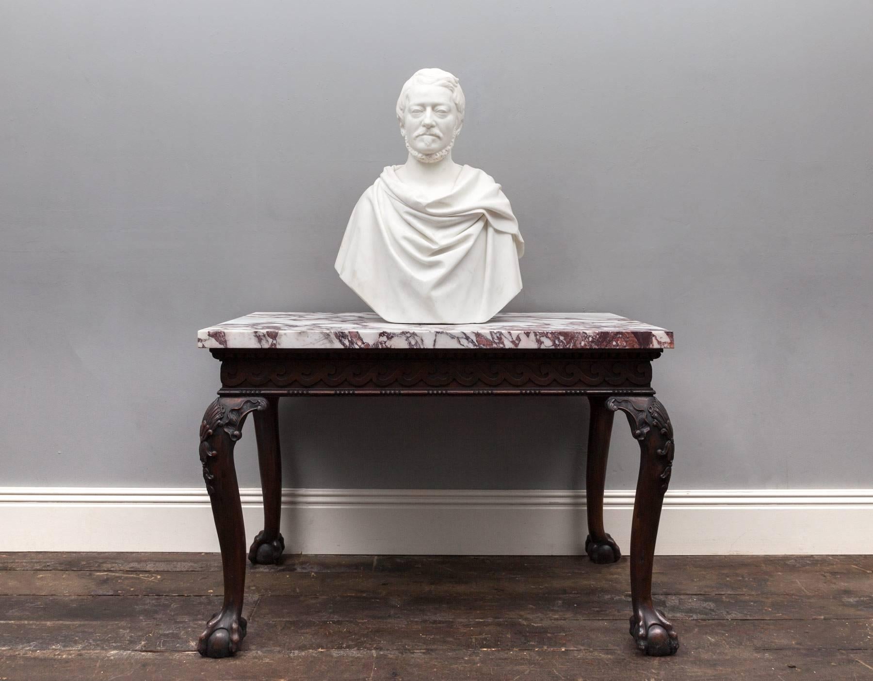 Antique statuary Carrara marble bust depicting a male in the classical Roman portrait style. Life-sized and beautifully carved in the purest of white statuary marble. 
The bust is of Sir Aubrey DeVere Hunt, 2nd Baronet (1788-1846), with stylized