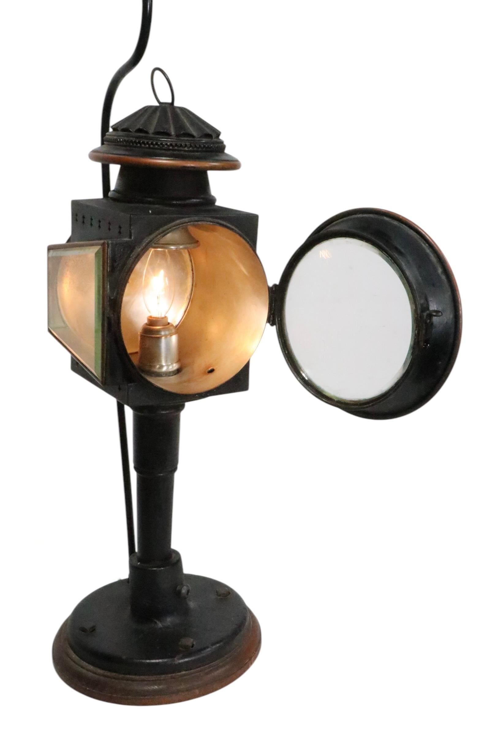 Interesting Steampunk style table lamp, featuring a 19th C carriage lamp, later mounted as a table lamp. The carriage lamp bas a circular front lens, which is hinged and opens, and a bevelled glass side window, to allow maximum illumination. The