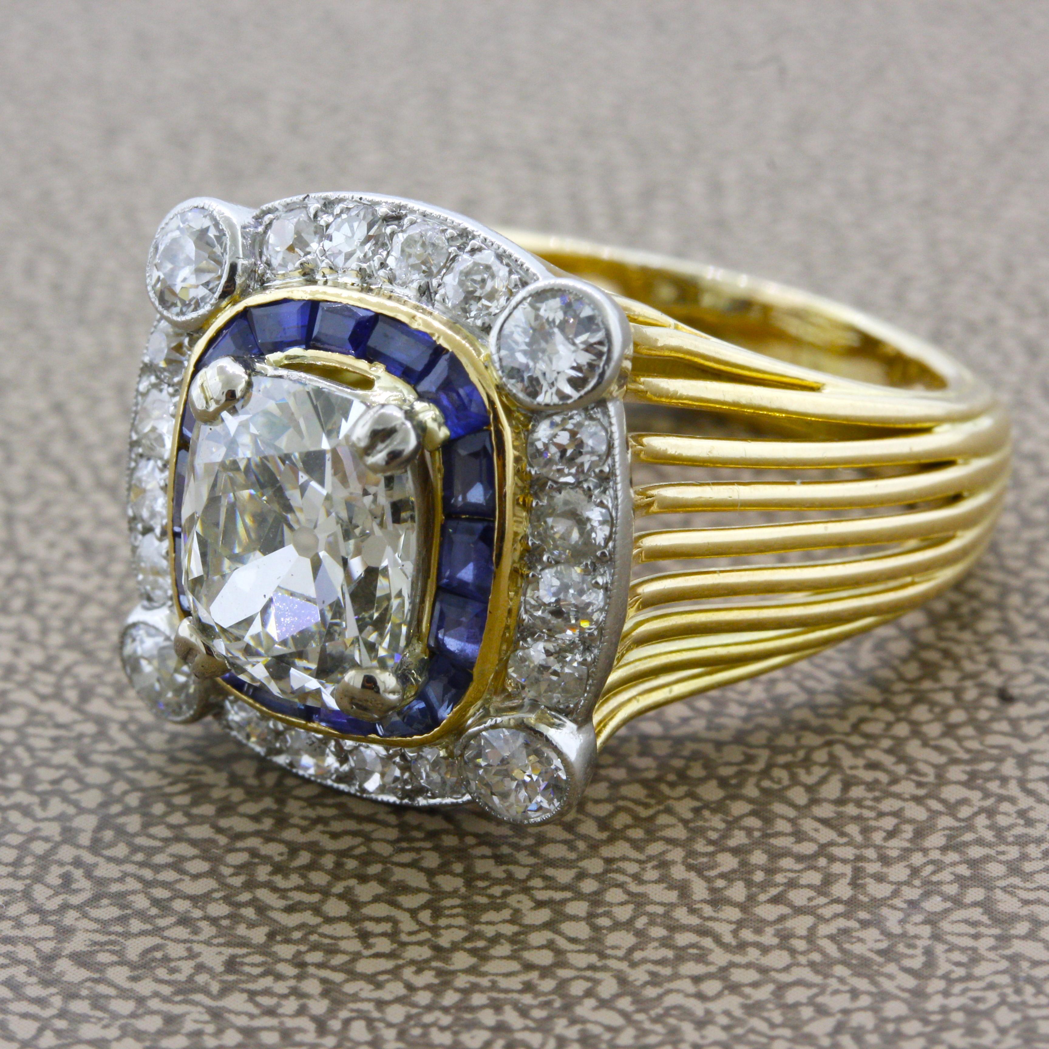 A Cartier original from the 1930’s featuring a 3.17 carat old-cushion-cut diamond with K color and SI1 clarity. Around the center diamond are a halo of blue sapphires as well as an outer halo of additional old-cut diamonds. Made in 18k yellow gold