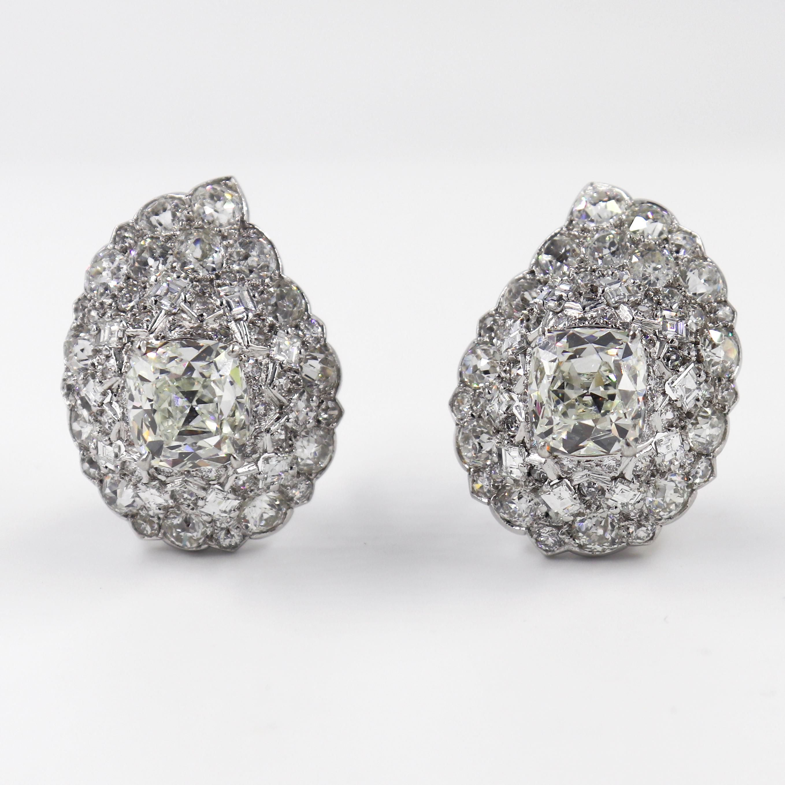 This extraordinary pair of platinum Cartier signed Art Deco era clip-on earrings features an approximately 5 carat cushion cut diamond surrounded by approximately 4 carats of rose cut diamonds for a total carat weight of 18 carats. These exquisite