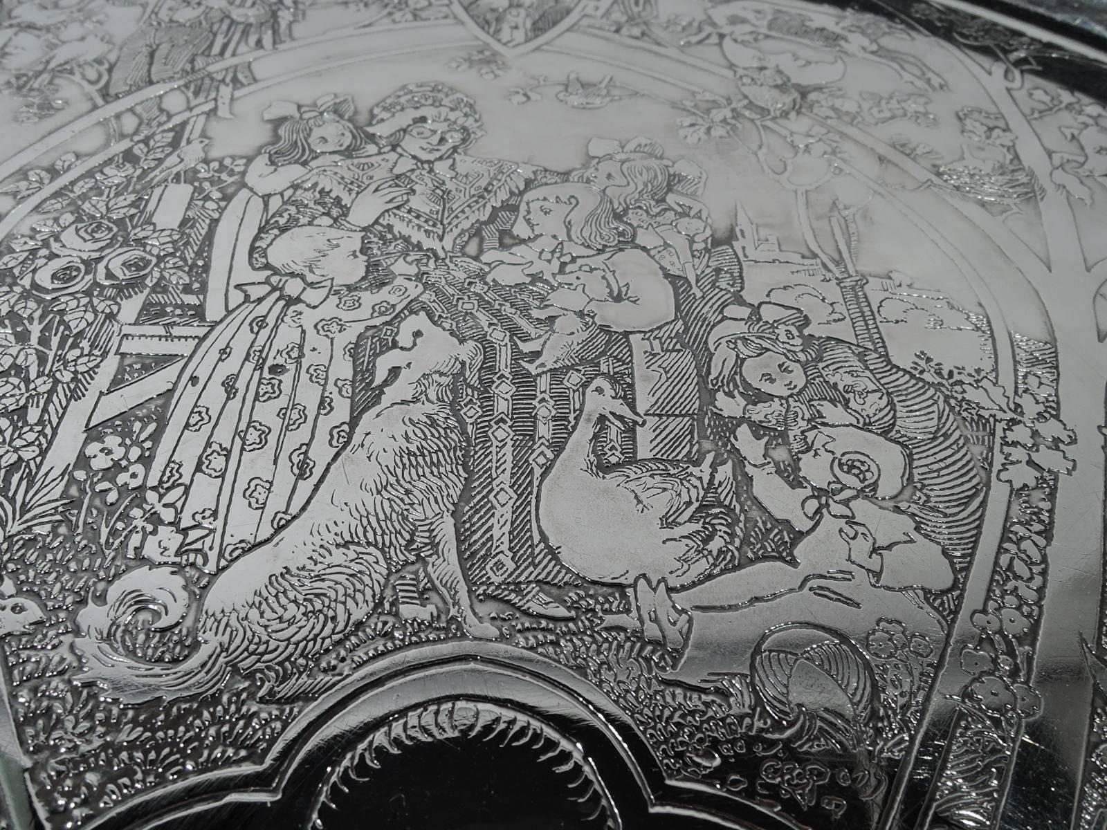 Edwardian sterling silver highchair tray. Retailed by Cartier in New York, 1910. Lunette-form with acid-etched scenes from Mother Goose, including Little Red Riding Hood, the Three Bears, and Humpty Dumpty. In center frame sits the old dame herself