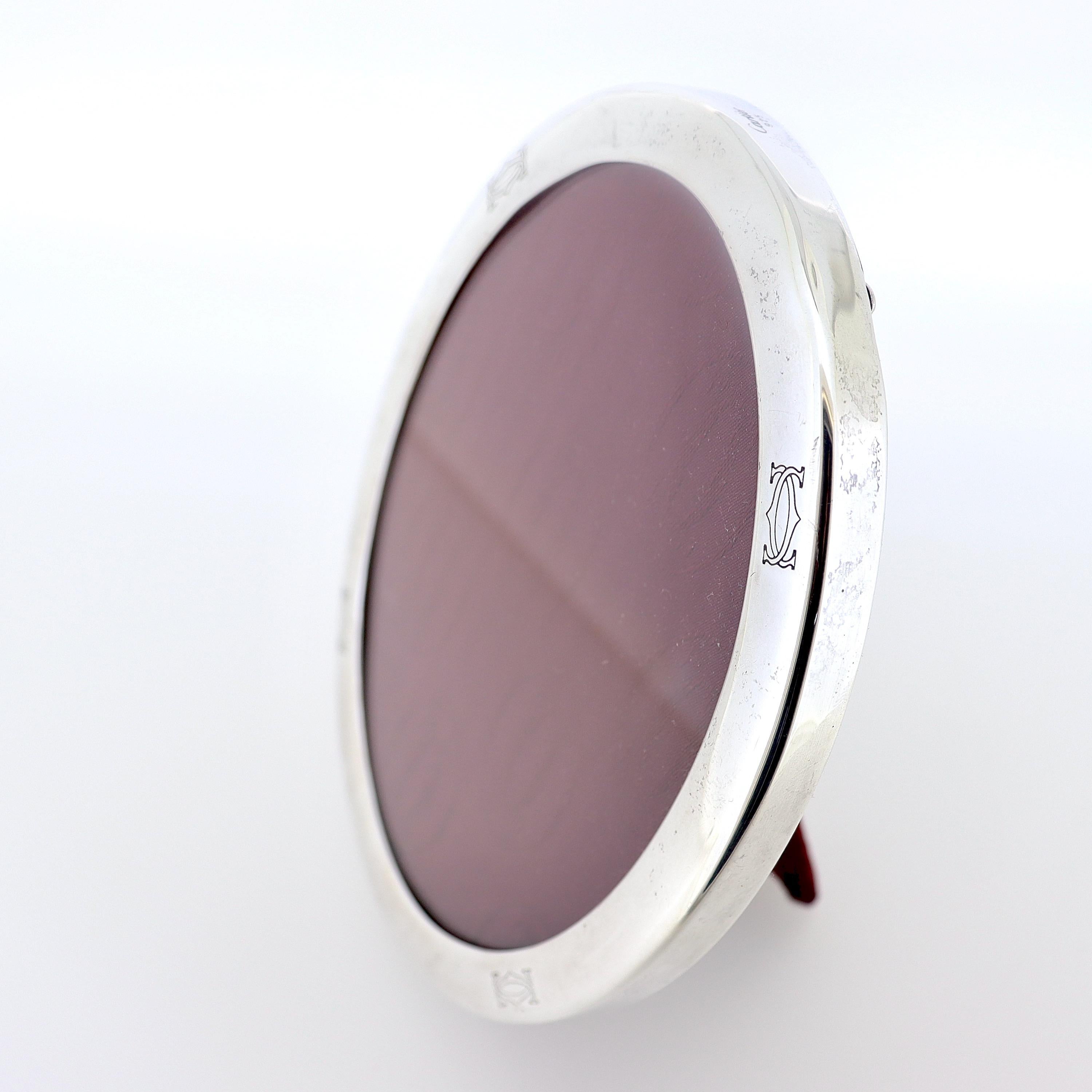 A fine vintage sterling silver photo or picture frame.

By Cartier.

In an oval shape with a red felt back. 

With the Cartier interlocking C logo engraved to the ordinal directions of the frame. 

Simply a great Cartier picture frame!

Date:
20th