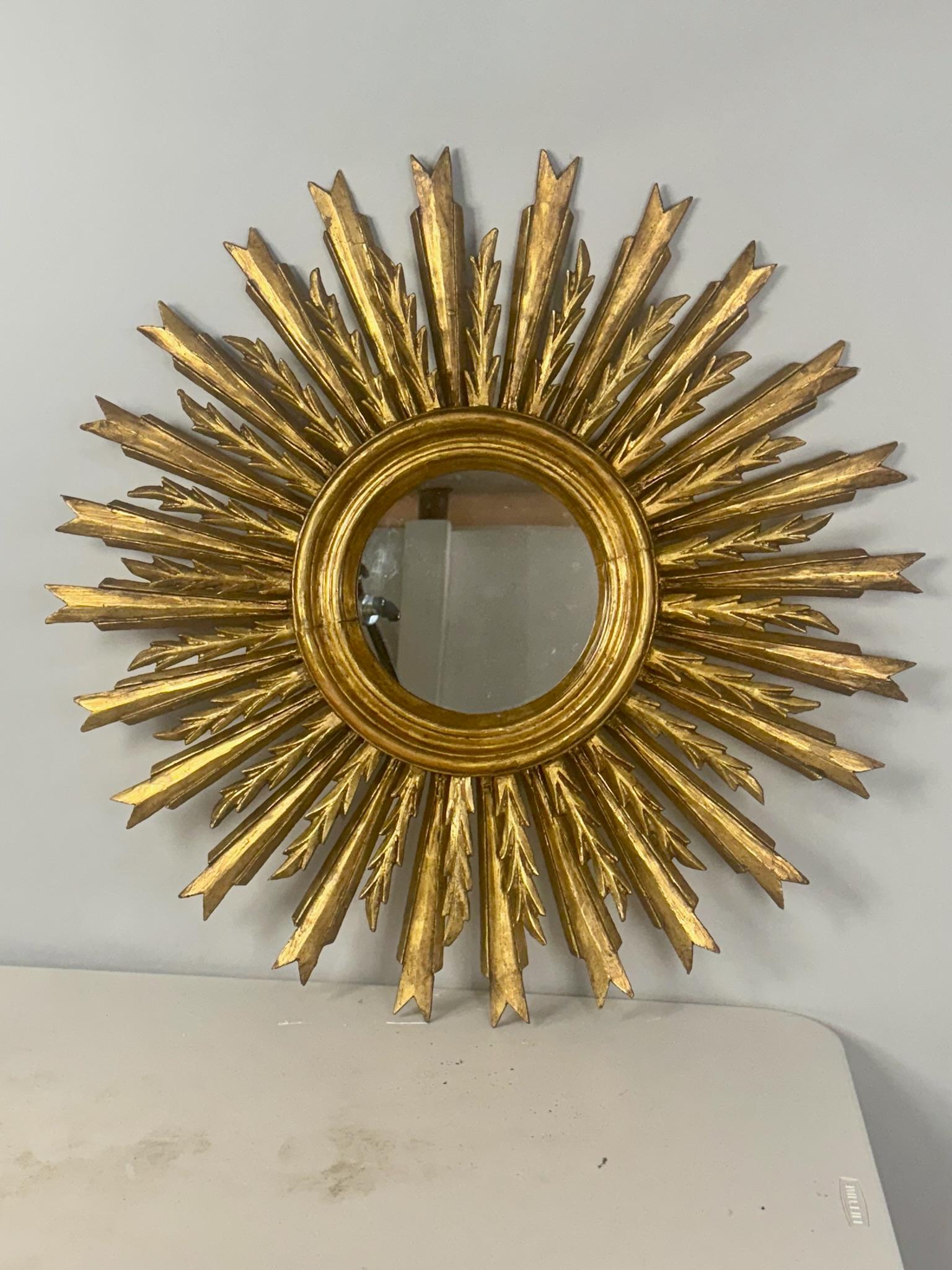 Precioso espejo francés dorado de rayos de sol (o de estrellas) con una doble hilera de rayos de madera dorada dispuestos alrededor del centro de la placa de cristal original del espejo. Cristal nuevo. Bonita pátina envejecida y dorado original en