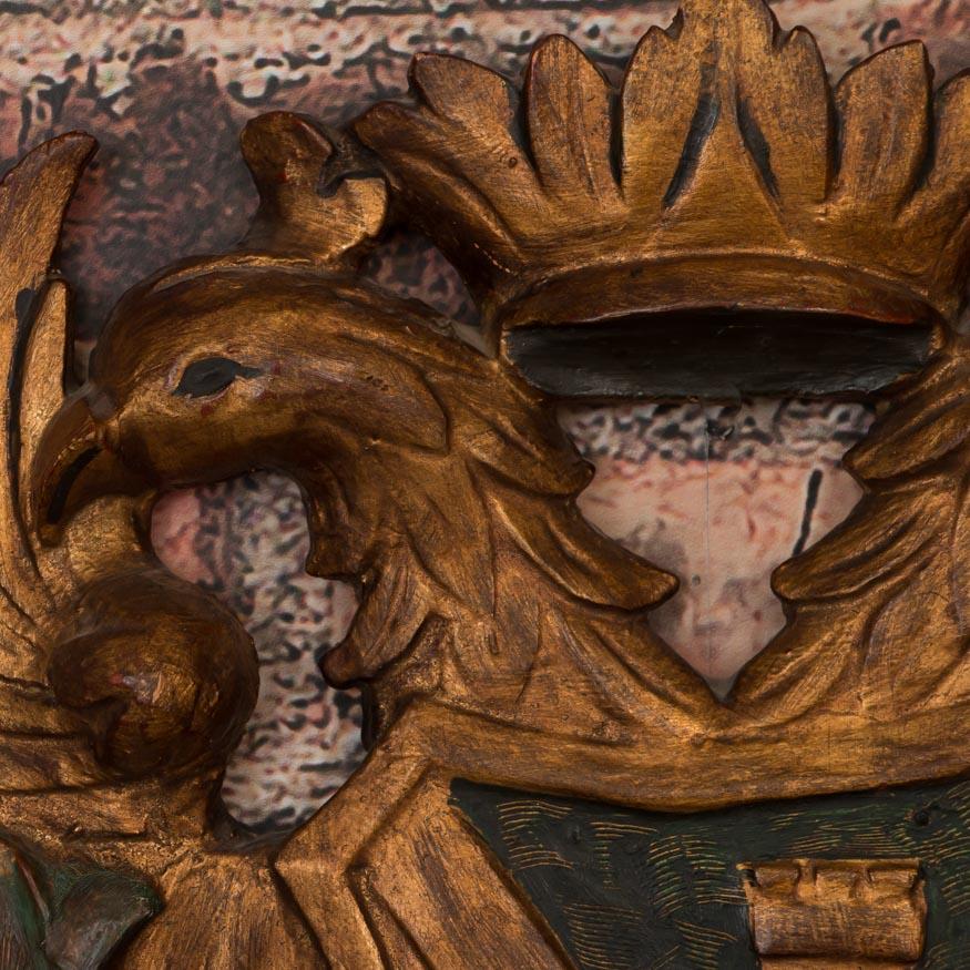This finely carved wood coat of arms plaque has a wonderful decorative appeal with it's vibrant gold, green and red paint. The carved double eagle with outspread wings is topped with a crown. Please take a moment to enlarge the photos and examine