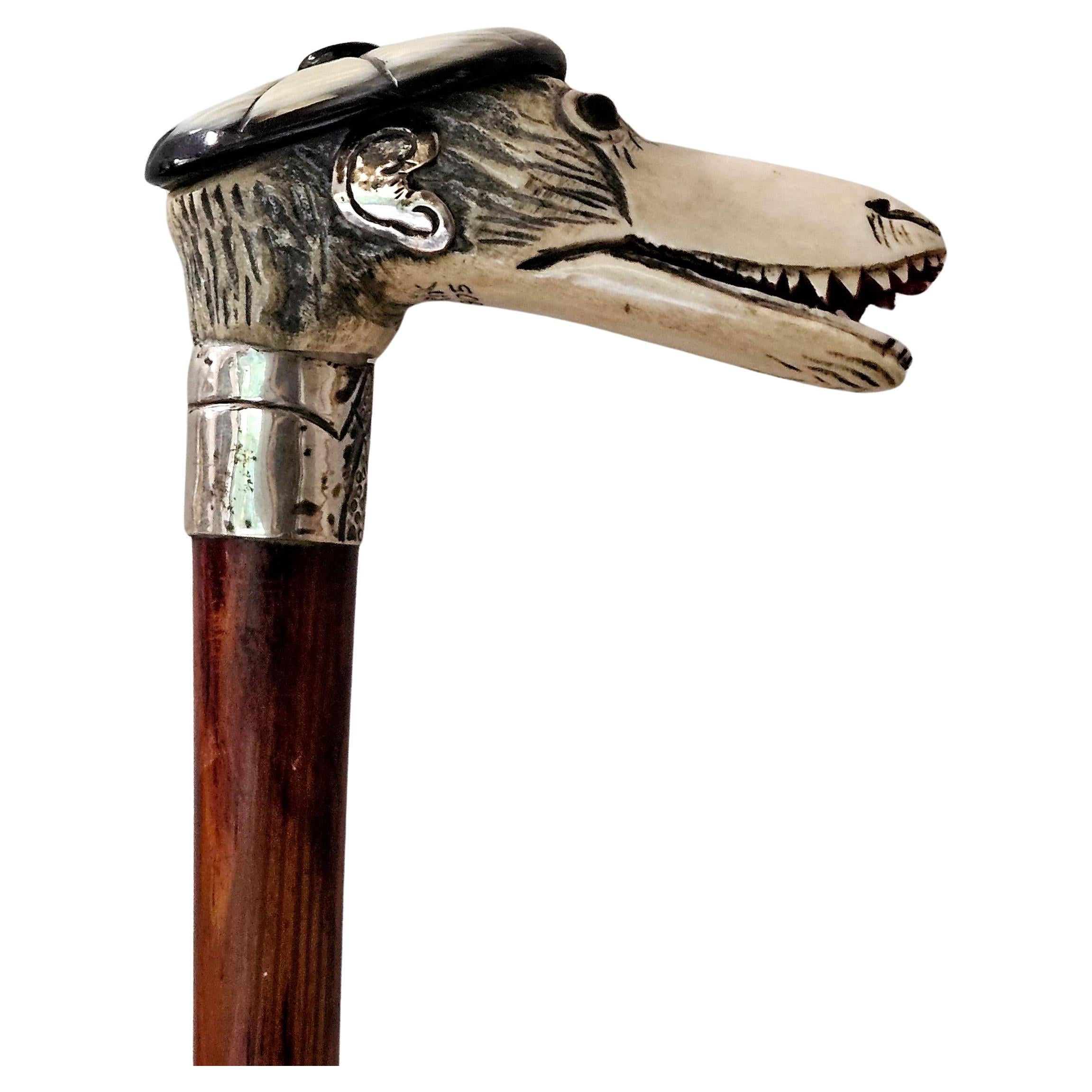  Bastón de hueso tallado con cabeza de mono (lleva sombrero y corbata Tam O'Shanter) de 10 cm de ancho y 35,5 cm de largo, con collar y orejas de plata de ley, firmado TARIK 1905.


 