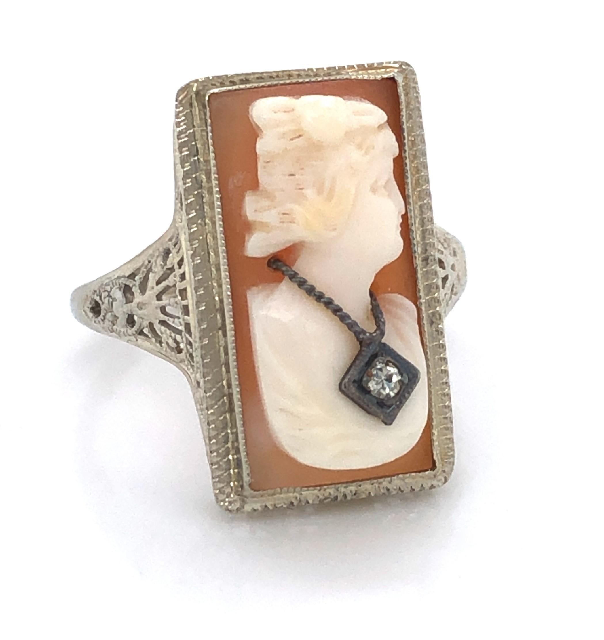 Elegantly presented in a fancy fourteen karat 14k white gold filigree antique ring setting, this hand carved natural shell cameo ring romantically portrays the bust of a fine lady of the period proudly wearing her decorative pendant. Artfully