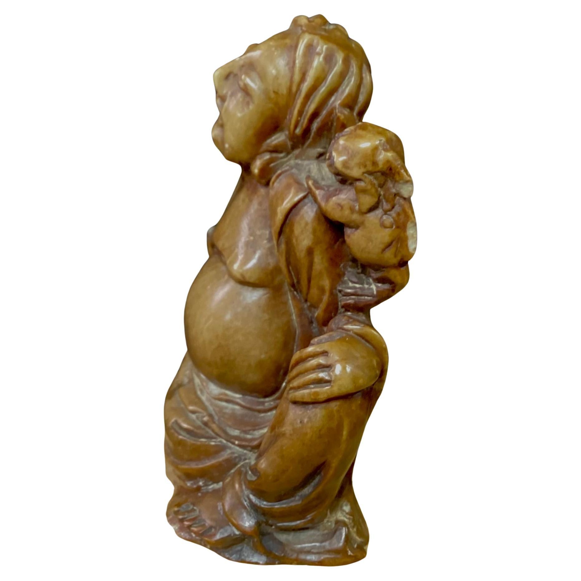 Chinesische Specksteinfigur aus dem 19. Jahrhundert, geschnitzt. Zeigt eine lächelnde Figur mit einem Foo Dog auf der Schulter und einem Kürbis in der anderen Hand, alles in brauner Farbe. 