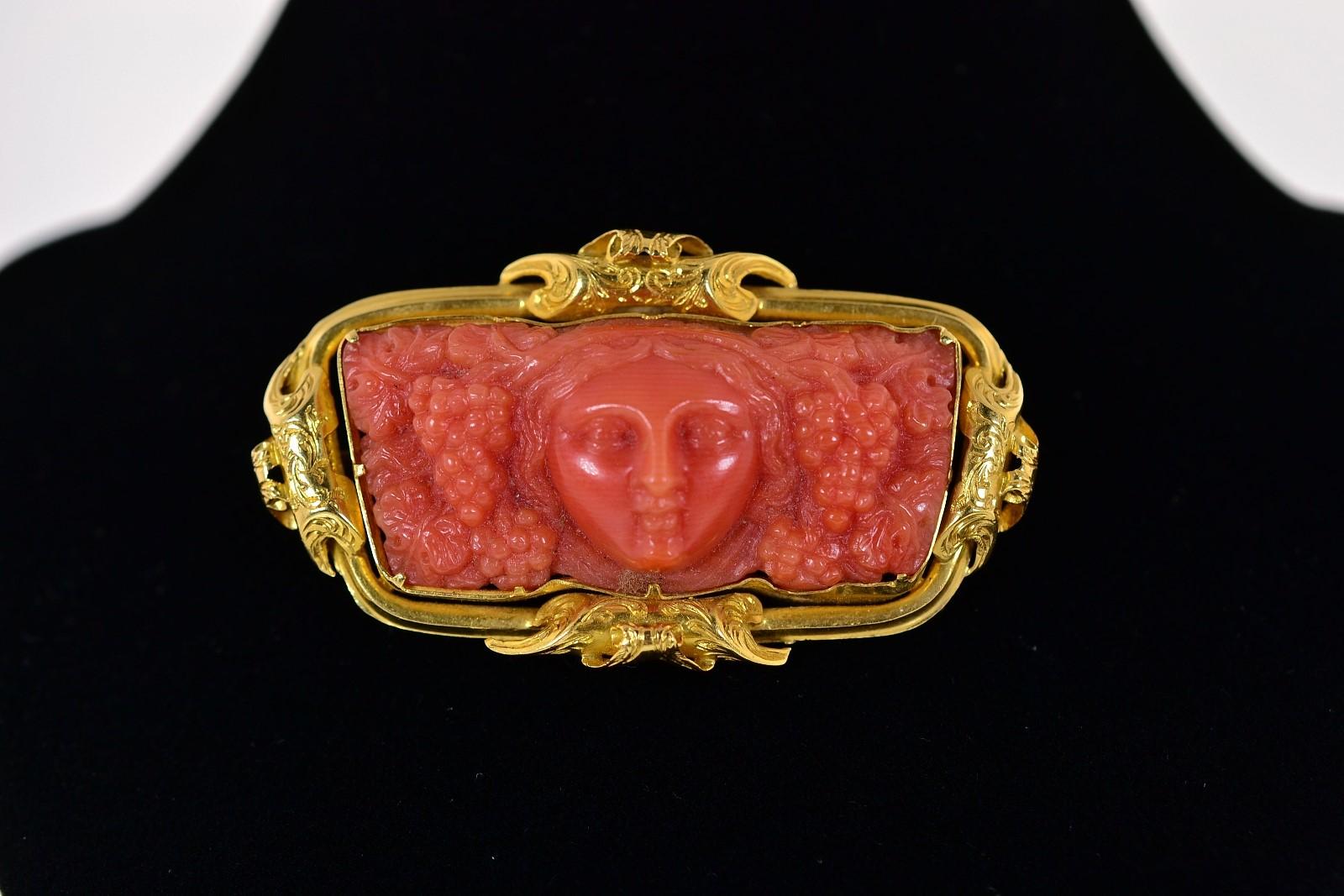 A coveted 1880s carved Coral depicting the Greek god of wine and fertility, Dionysus.  The beautifully carved plaque of Coral is set in a 14KT yellow gold frame with four elaborate swirl designs.  Gorgeous!