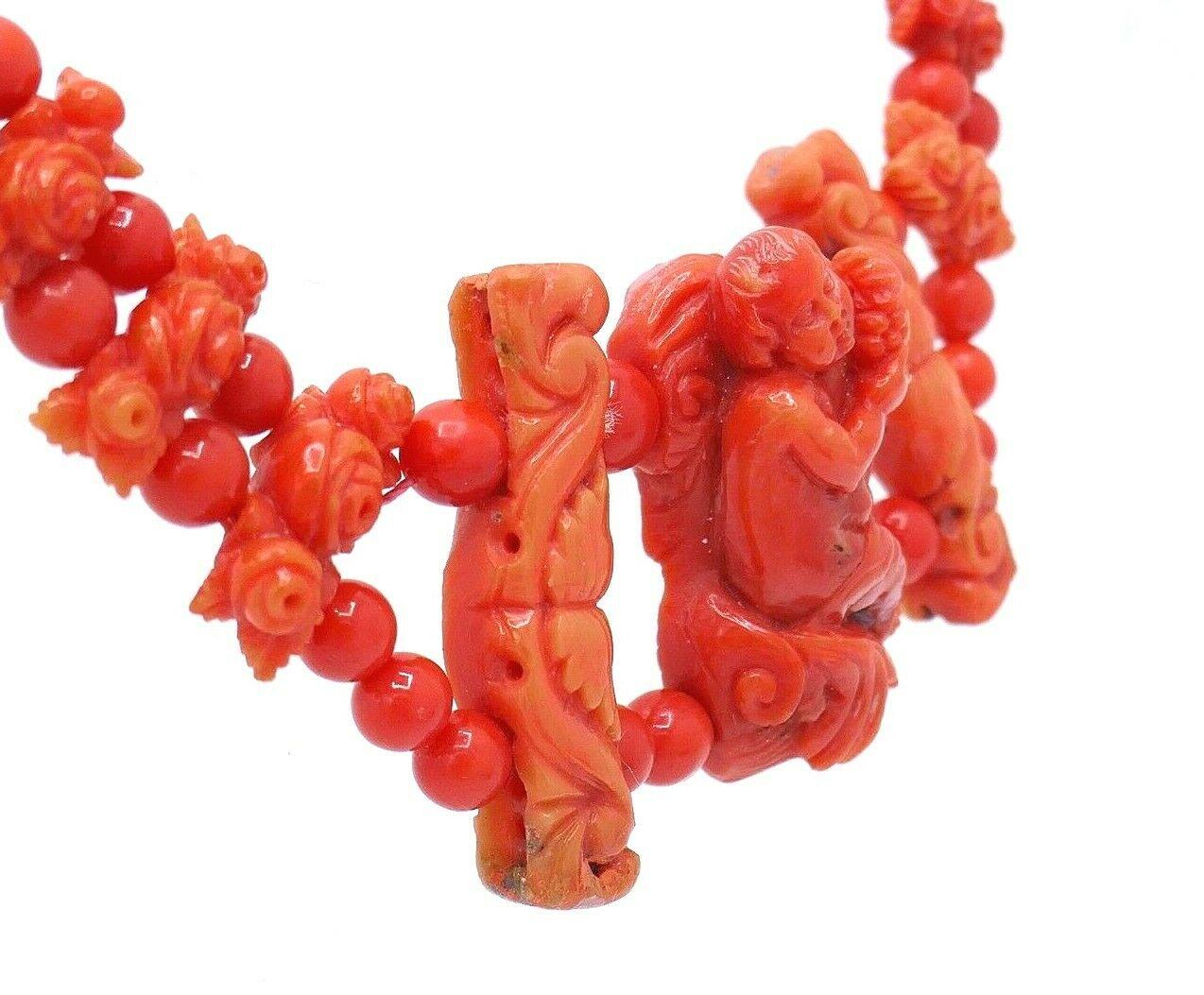 Unique carved coral necklace (circa 1900). The central part is a carved figure of a boy holding a grape. On the sides there are floral elements and the rest are beads. Featuring 14k (stamped) yellow gold clasp.  
Measurements: 16