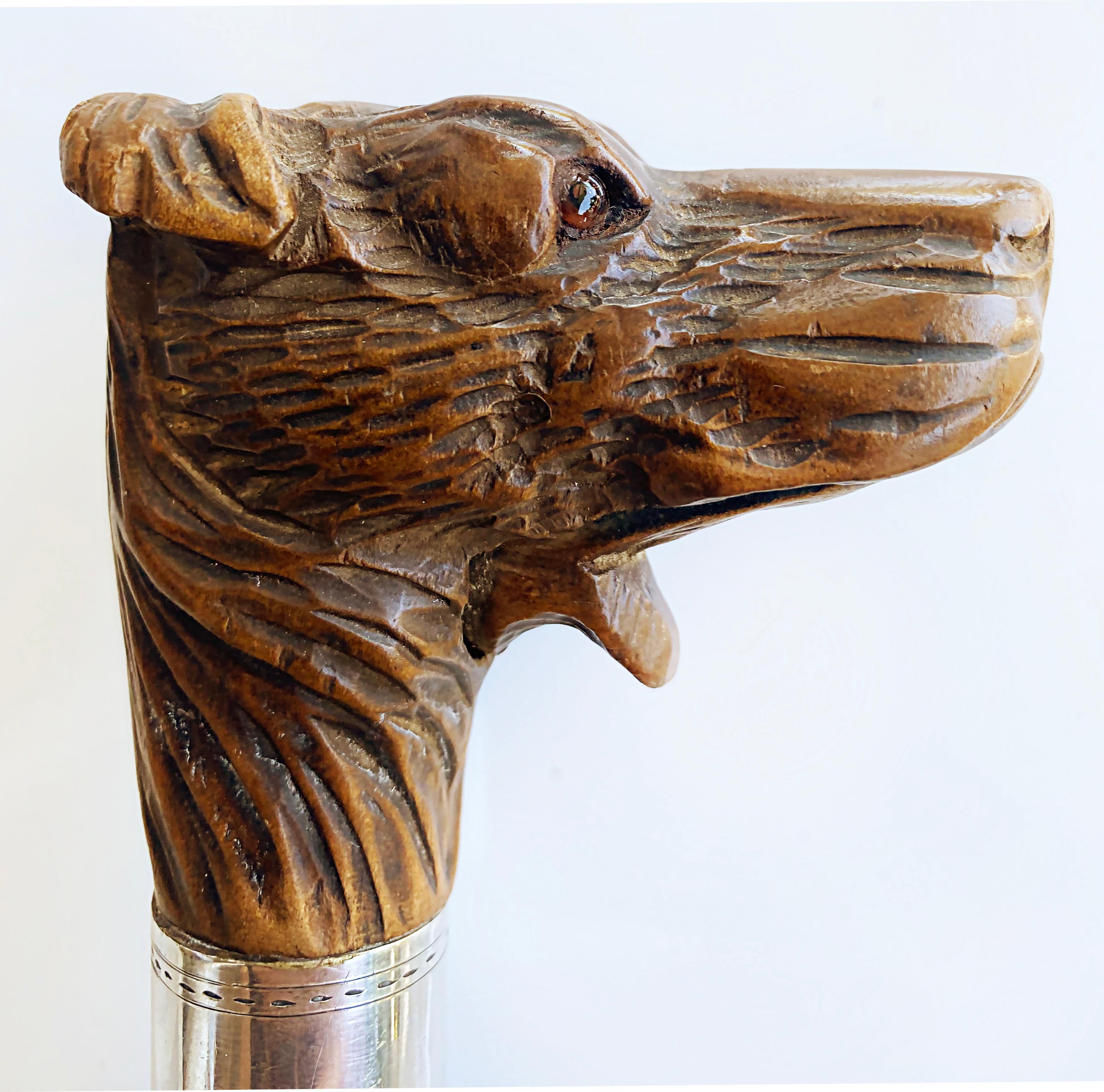 Antique Carved Dog Glove Holder Walking Stick Cane with Silver Banding

Offered for sale is a late 19th to early 20th-century antique hand-carved dog glove holder walking stick cane that has a silver band at the neck. The head has glass eyes. This