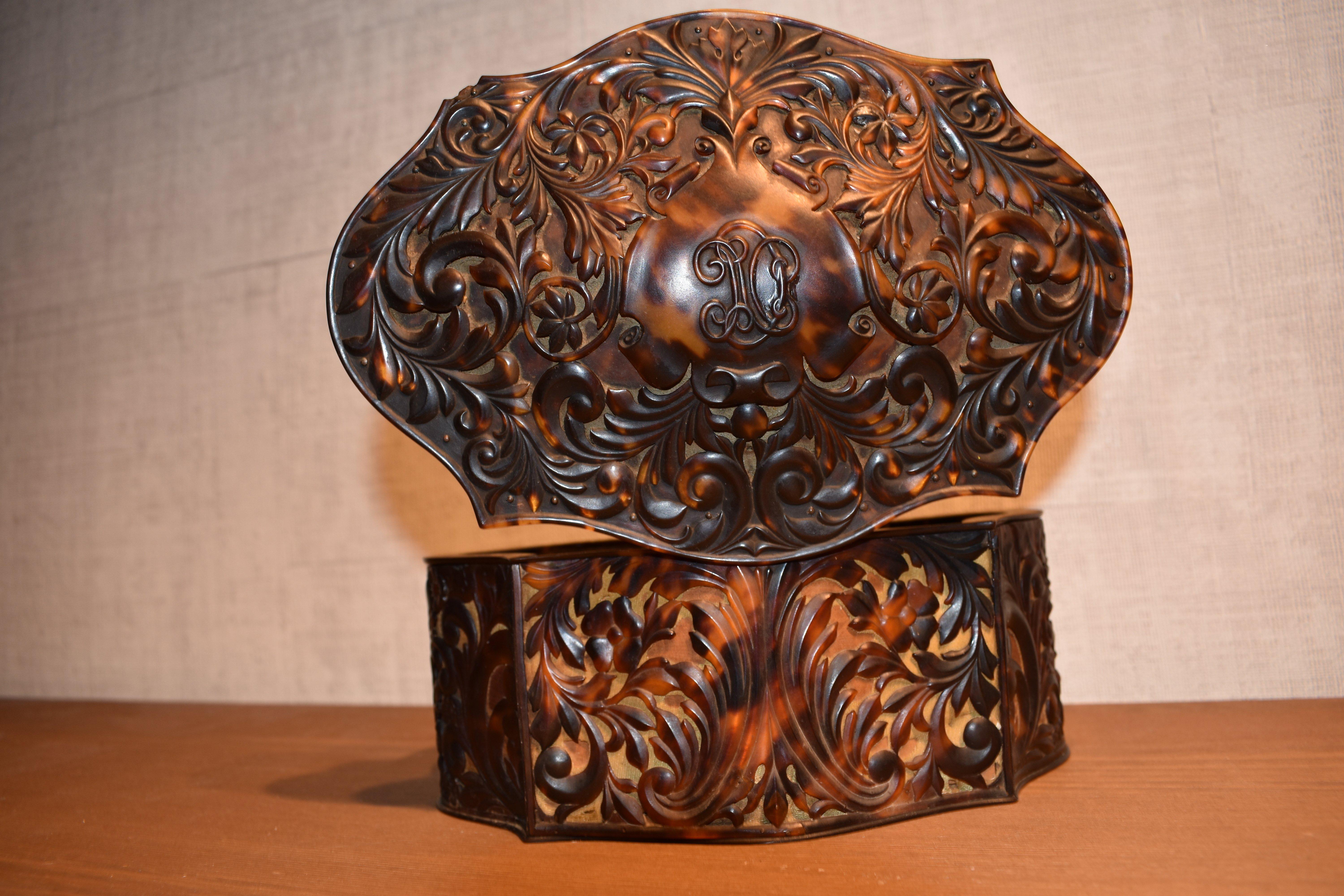 Information:
This impressive jewelry box is beautifully crafted. It is covered with carved plates of realistic looking faux tortoiseshell. The carvings are very detailed and sophisticated; in addition the box has a rare shape. The inside is lined