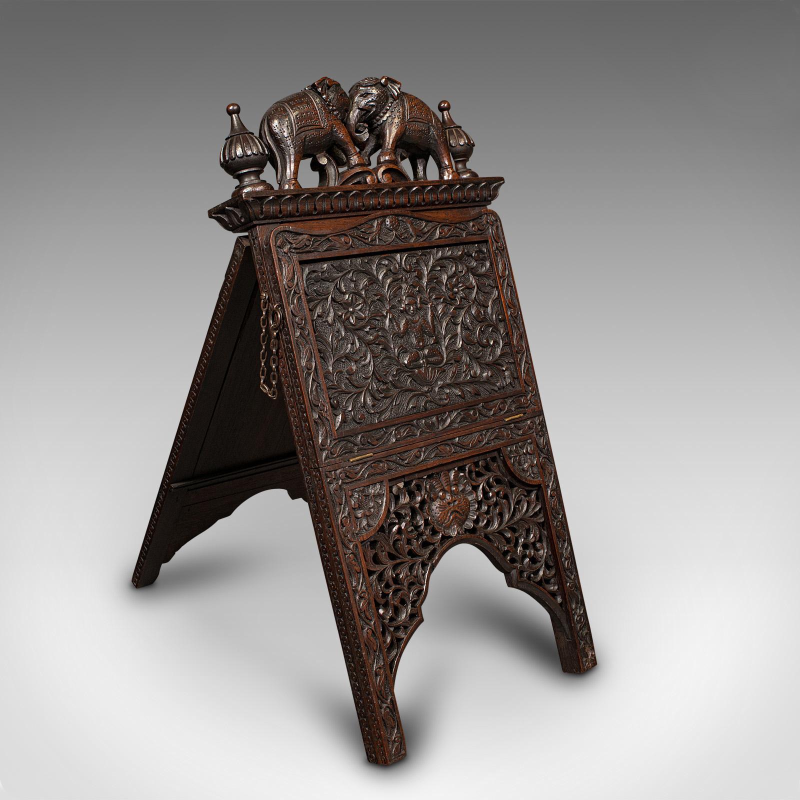 This is an antique carved folio stand. A Burmese, mahogany folding gentleman's newspaper rack, dating to the early Victorian period, circa 1850.

Excellent craftsmanship with striking carved detail.
Displays a desirable aged patina and in superb