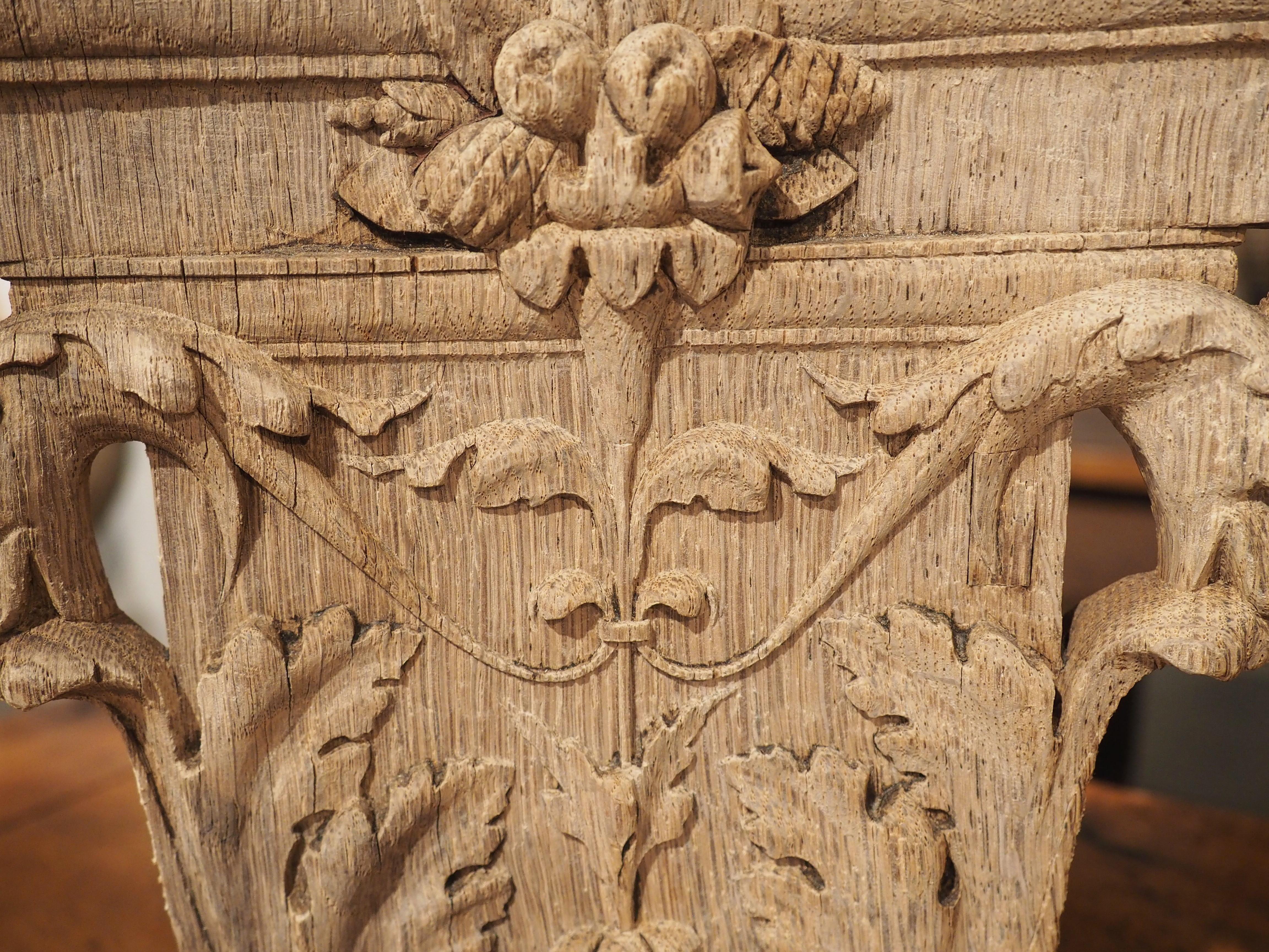 Hand-carved in France on “1er Octobre 1841” (see photo of the verso side), this oak capital features a large floral display beneath the molded entablature. There is a fruit and pinecone grouping that sits on top of the petals and extends onto the