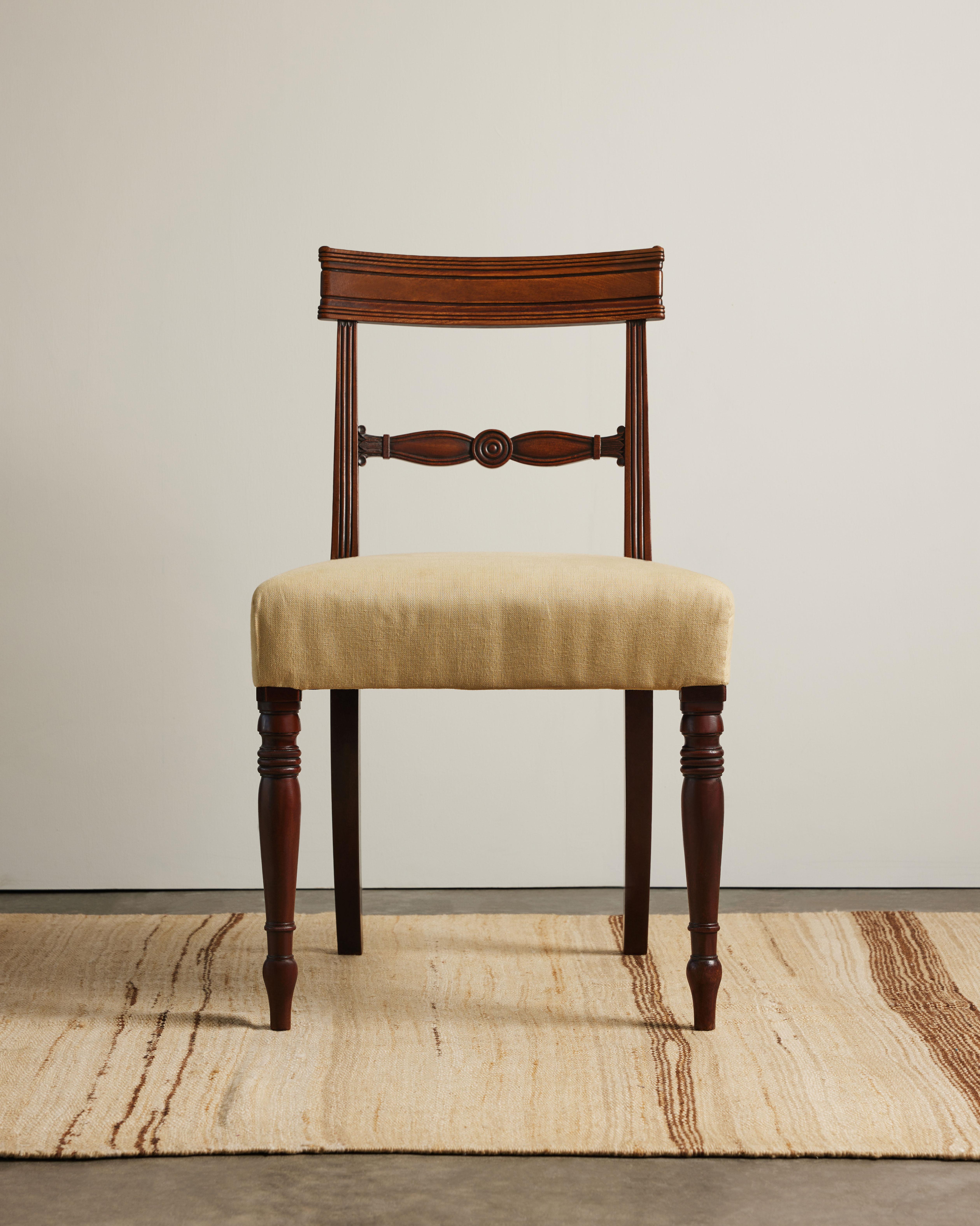 Preciosa silla de madera de frutal de estilo Regencia con asiento de lino recién tapizado. Esta pieza presenta detalles torneados en las patas delanteras de husillo y ornamentación tallada en el soporte trasero.

Una silueta atractiva desde todos