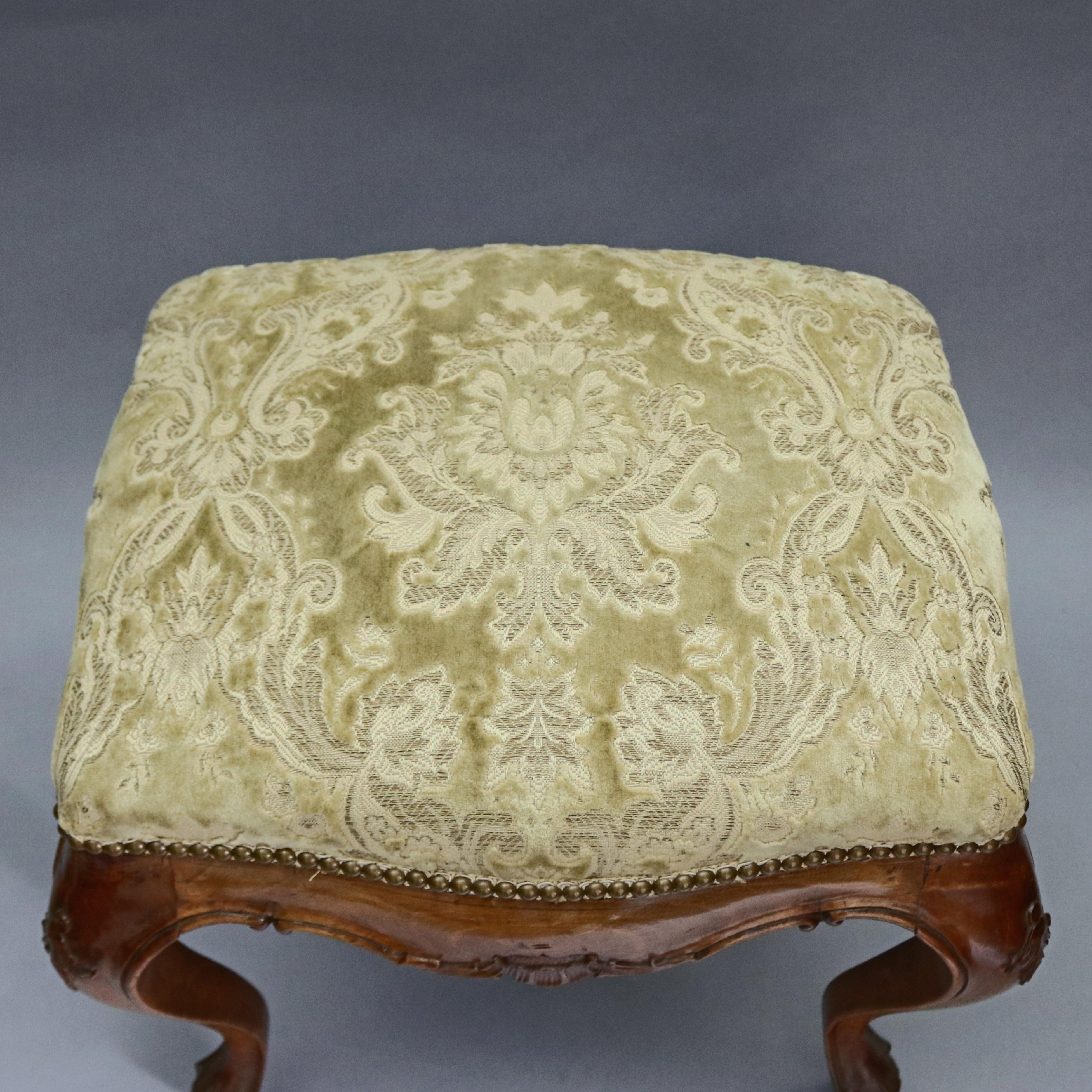 Antique French Renaissance style bench offers carved fruitwood frame with shaped skirt having central shell with flanking foliate decoration, raised on cabriole legs surmounted by upholstered seat, circa 1900.

Measures: 20.5