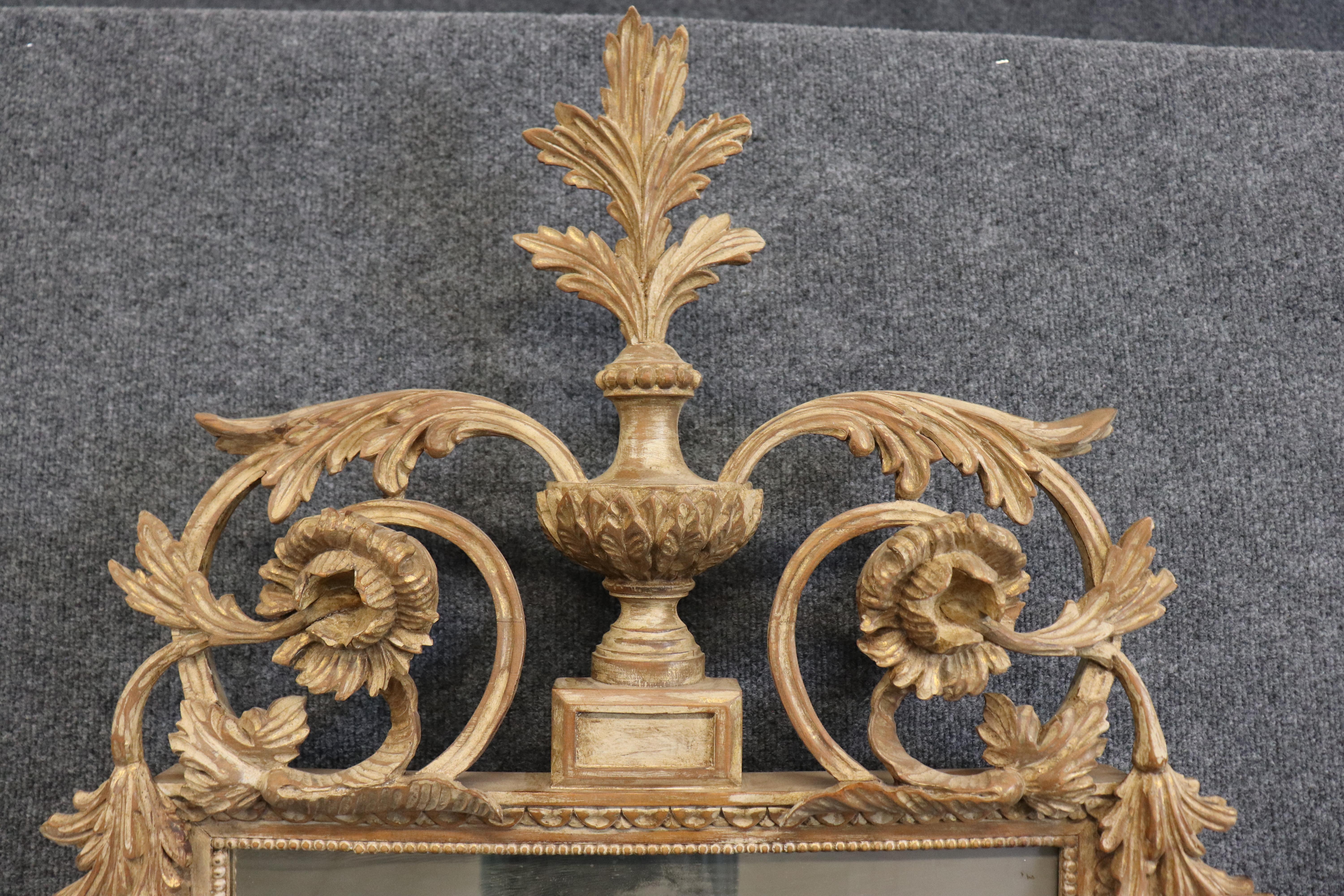 Il s'agit d'un magnifique miroir ancien de style Louis XV, fabriqué en Italie. Le miroir est magnifique, avec des fleurs et des détails sculptés absolument incroyables. La finition est usée par le temps et le cadre présente de petites zones