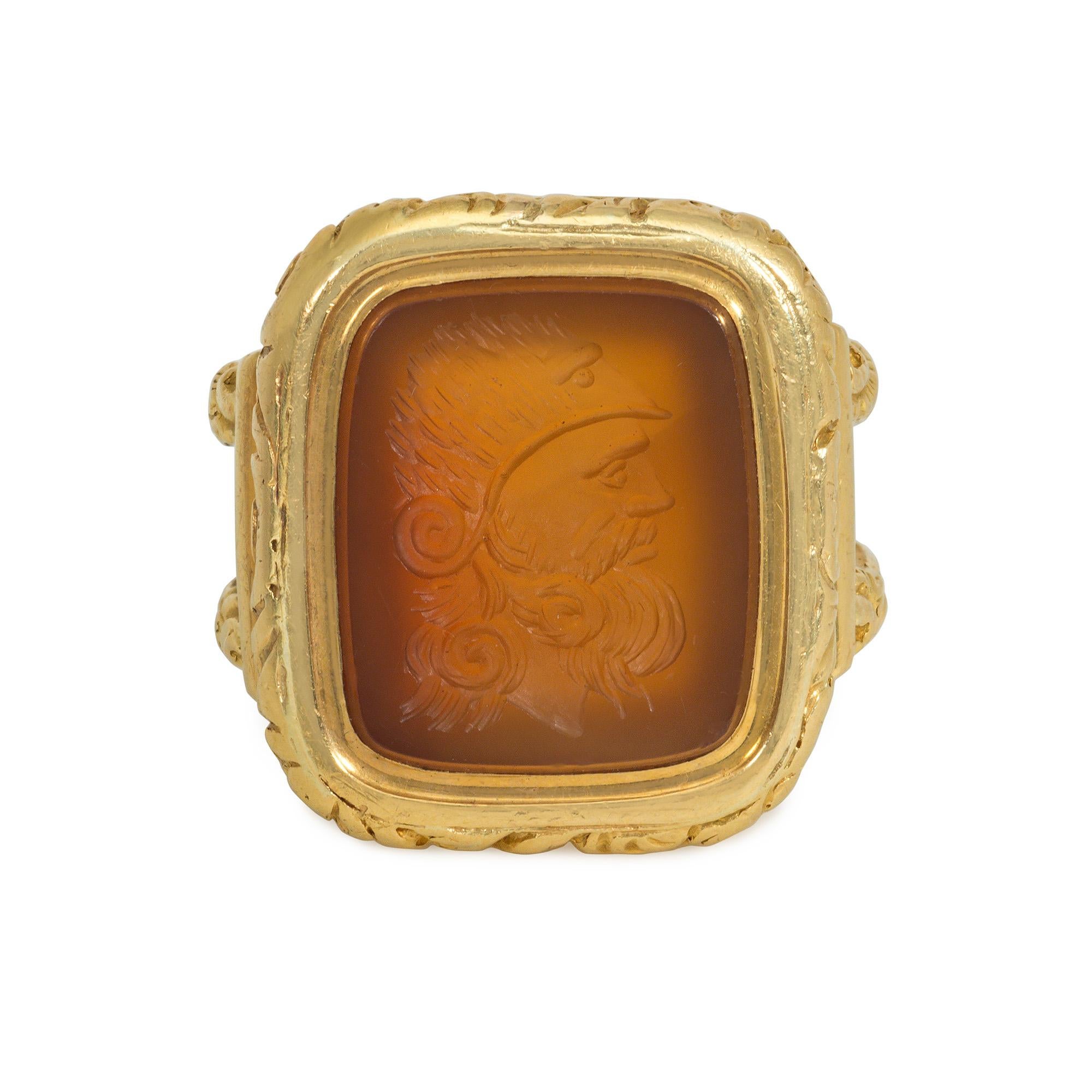 Bague d'époque victorienne en or et intaille de cornaline représentant le buste d'un guerrier antique coiffé d'un casque, dans une monture à feuillage sculpté, avec un large manche décoré de motifs nervurés et feuillagés, en 18k.

Dimensions face à