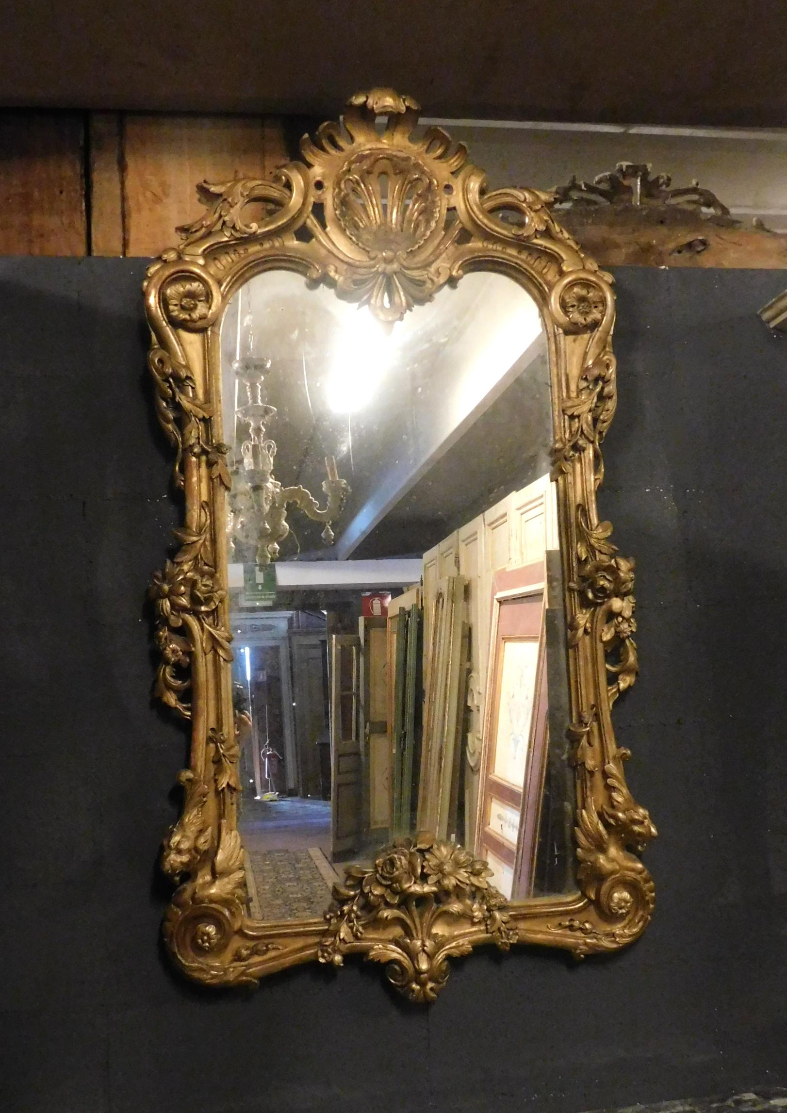 Miroir ancien en bois doré sculpté, très riche et si décoré de motifs floraux, traitements spéciaux, élégance et raffinement provenant d'une maison de luxe en Italie, convient pour être placé au-dessus des cheminées ou accroché au mur, rendra vos