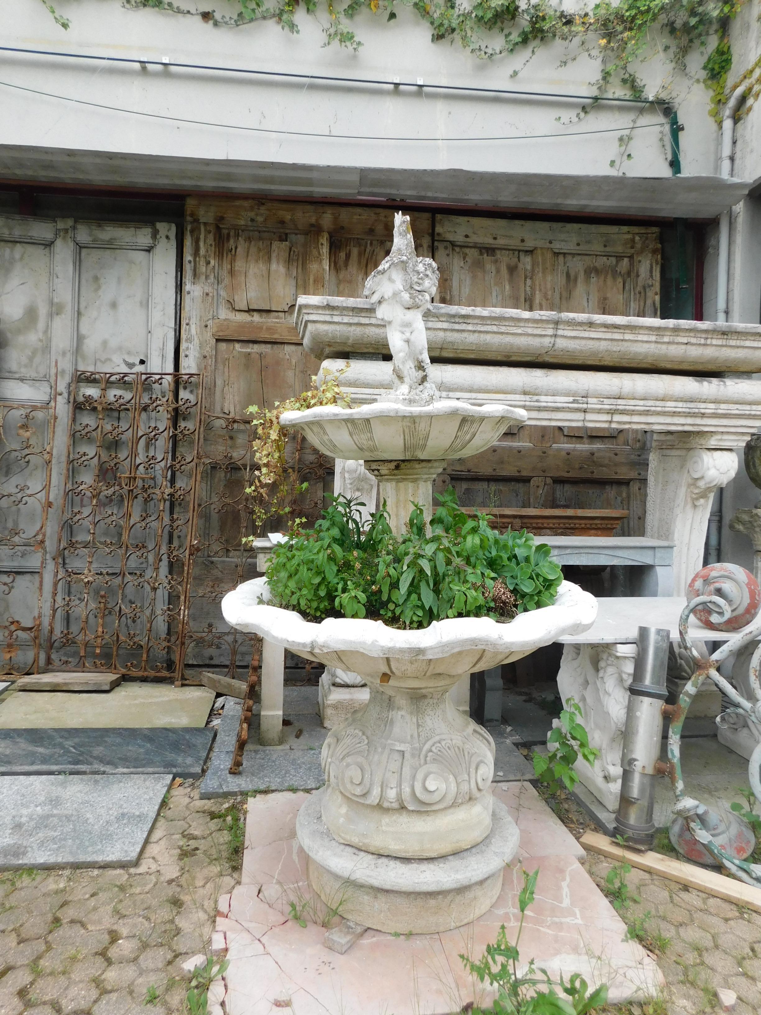 Ancient fountain in gray stone, entirely hand-carved with putto on top, decorated double basin and central column with sculpted modules, original from the 19th century, from an Italian garden.
Ideal for setting up your garden or outdoor space,