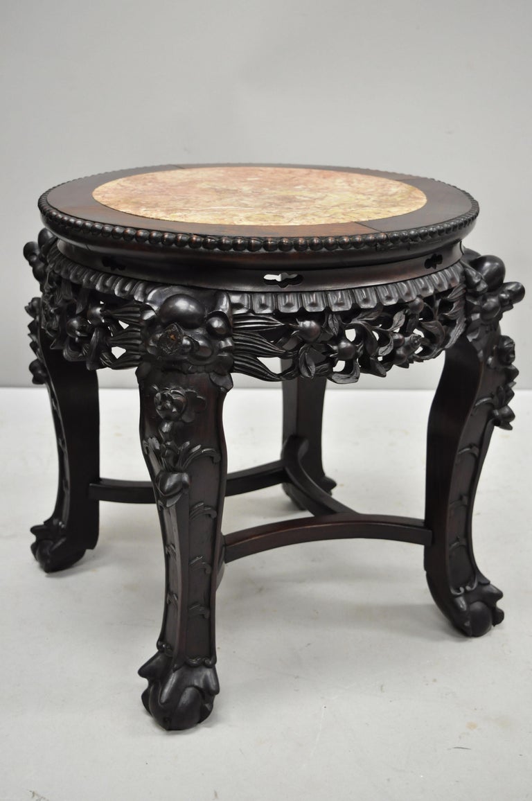 Antique carved hardwood rosewood and marble-top Chinese pedestal table (B). Item features inset marble top, pierce carved floral skirt, carved stretcher base, solid wood construction, finely carved details, very nice antique item, circa late