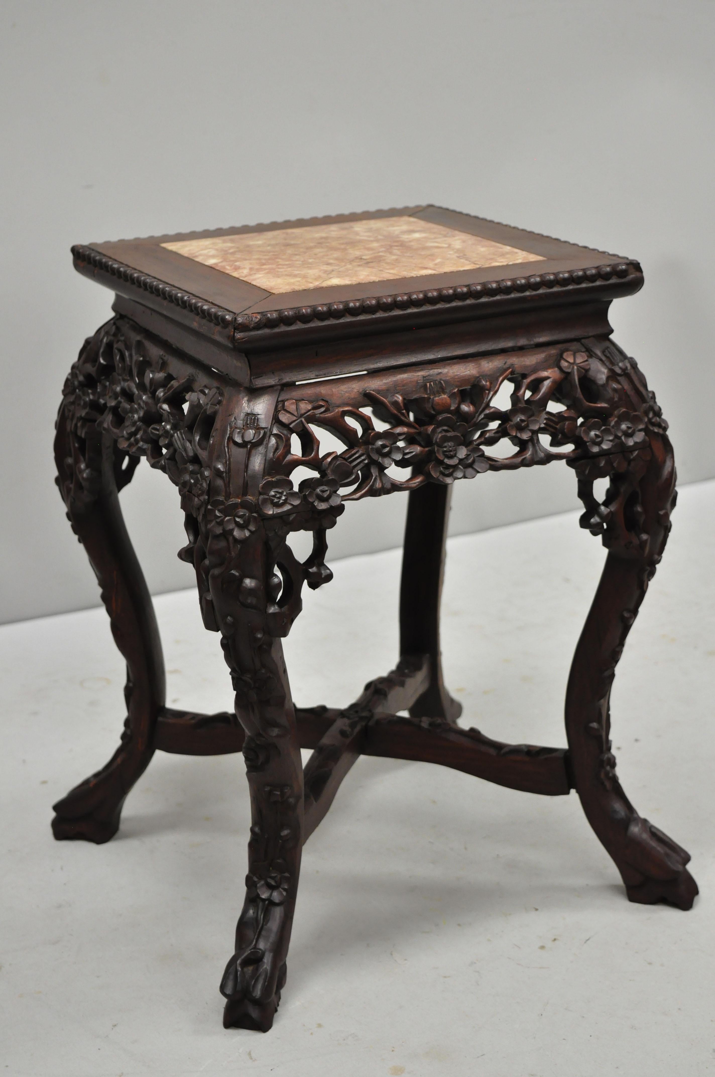 Antique carved hardwood rosewood and square marble top Chinese pedestal table (D). Item inset marble-top, pierce carved floral skirt, carved stretcher base, solid wood construction, finely carved details, very nice antique item, circa late 19th-20th