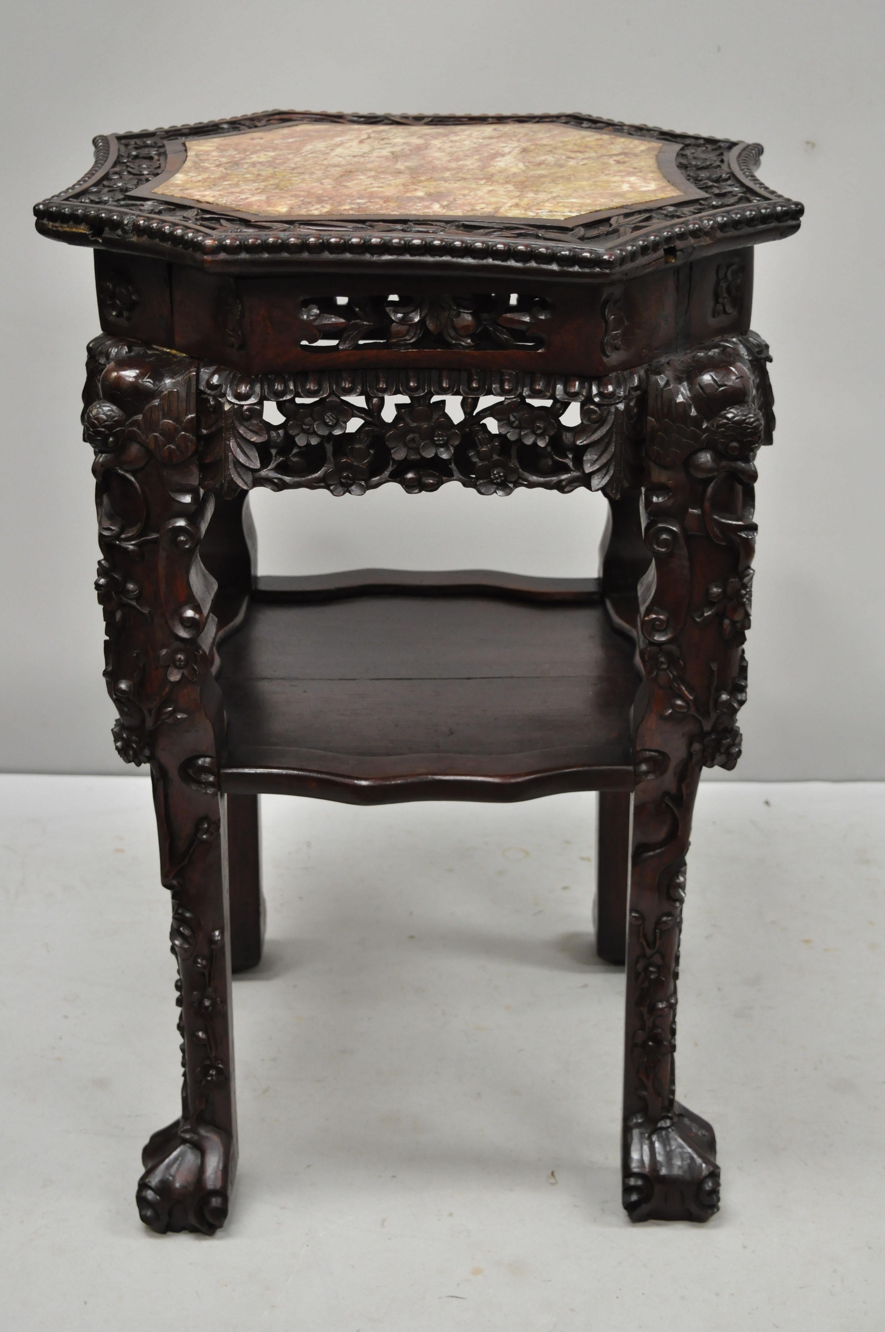 Antique carved hardwood rosewood and marble top Chinese pedestal table (G). Item features inset marble top, pierce carved floral skirt, carved lower shelf, solid wood construction, finely carved details, very nice antique item, circa Late 19th-20th