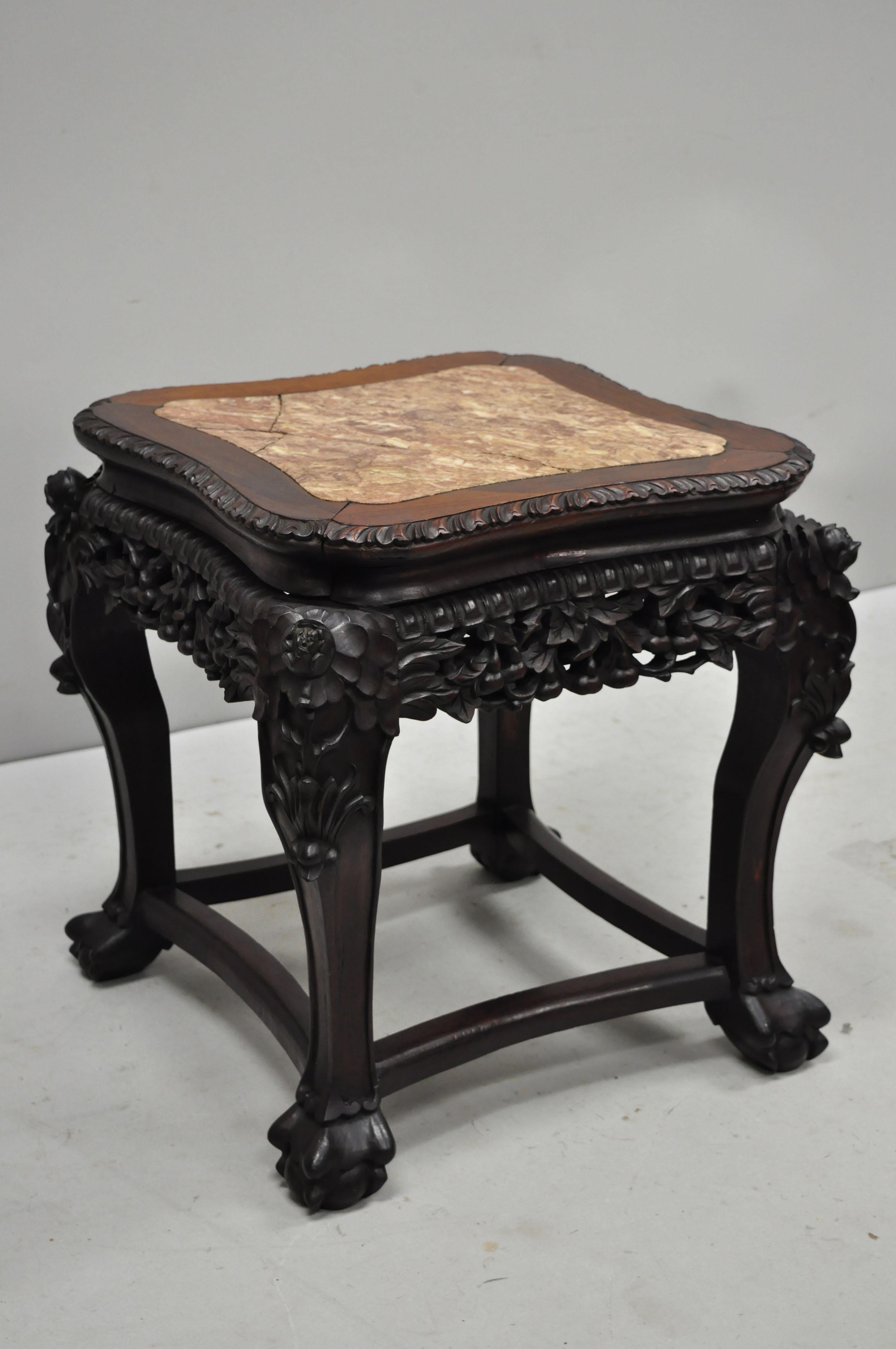 Antique carved hardwood rosewood and marble-top Chinese pedestal table (H). Item features inset marble top, pierce carved floral skirt, carved stretcher base, solid wood construction, finely carved details, very nice antique item, circa late