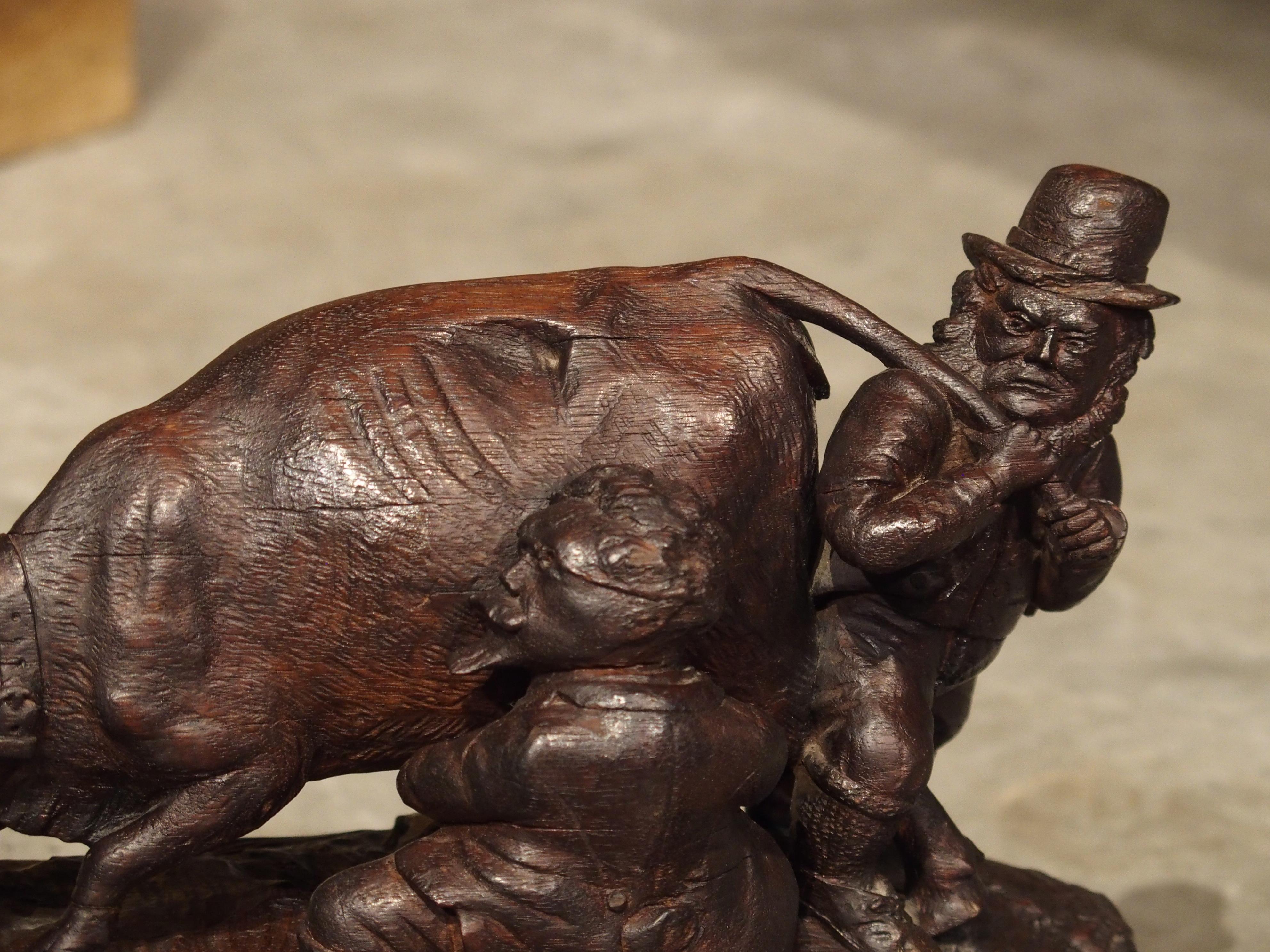 This intriguing Black Forest inkwell has been meticulously hand carved from wood and dates to 19th century Switzerland.

The piece depicts two men attempting to milk a cow. The man wearing a hat is struggling to control the cow by pulling on the