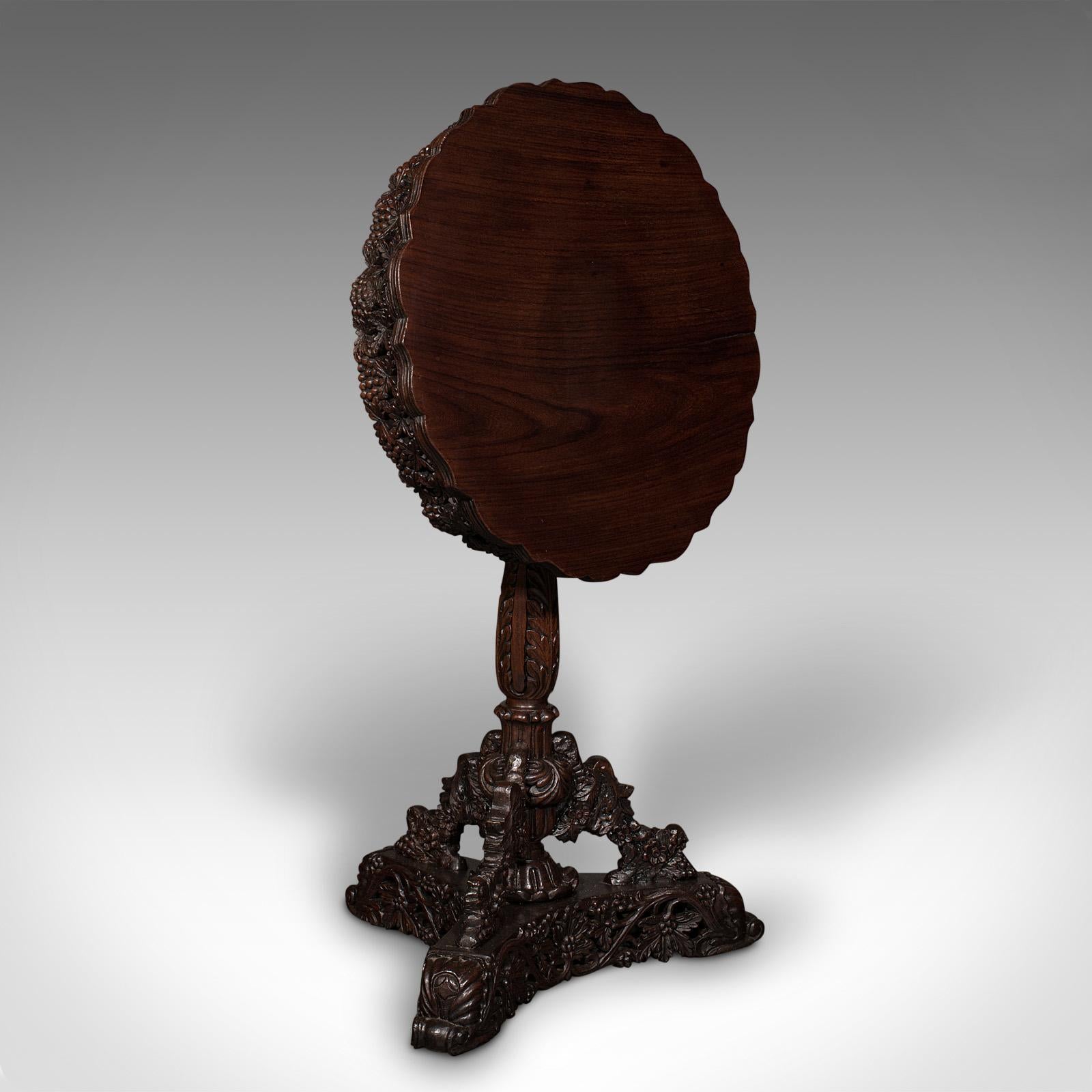 Il s'agit d'une ancienne table de lampe sculptée. Table coloniale anglo-indienne à plateau basculant en teck, datant de la période victorienne, vers 1850.

Superbe qualité, avec d'excellents détails sculptés et un plateau inclinable.
Présente une