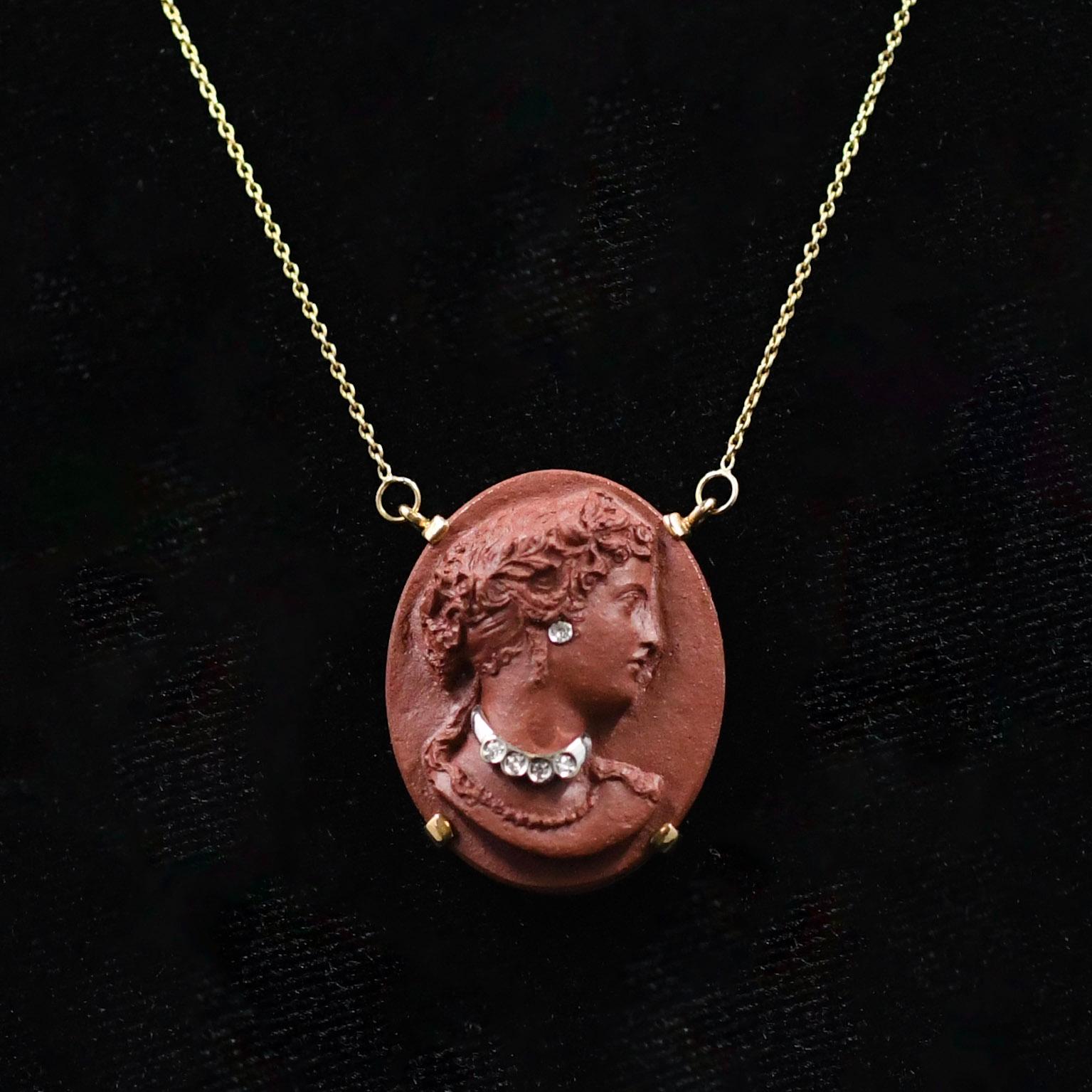 Indulge in the timeless allure of this carved lava cameo habille necklace with diamond accents, elegantly suspended from a 14k yellow gold chain. This exquisite piece of jewelry showcases the artistry of cameo carving and the luxury of diamond