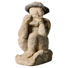 Statue antique en pierre calcaire sculptée d'un garçon jouant de la cornemuse