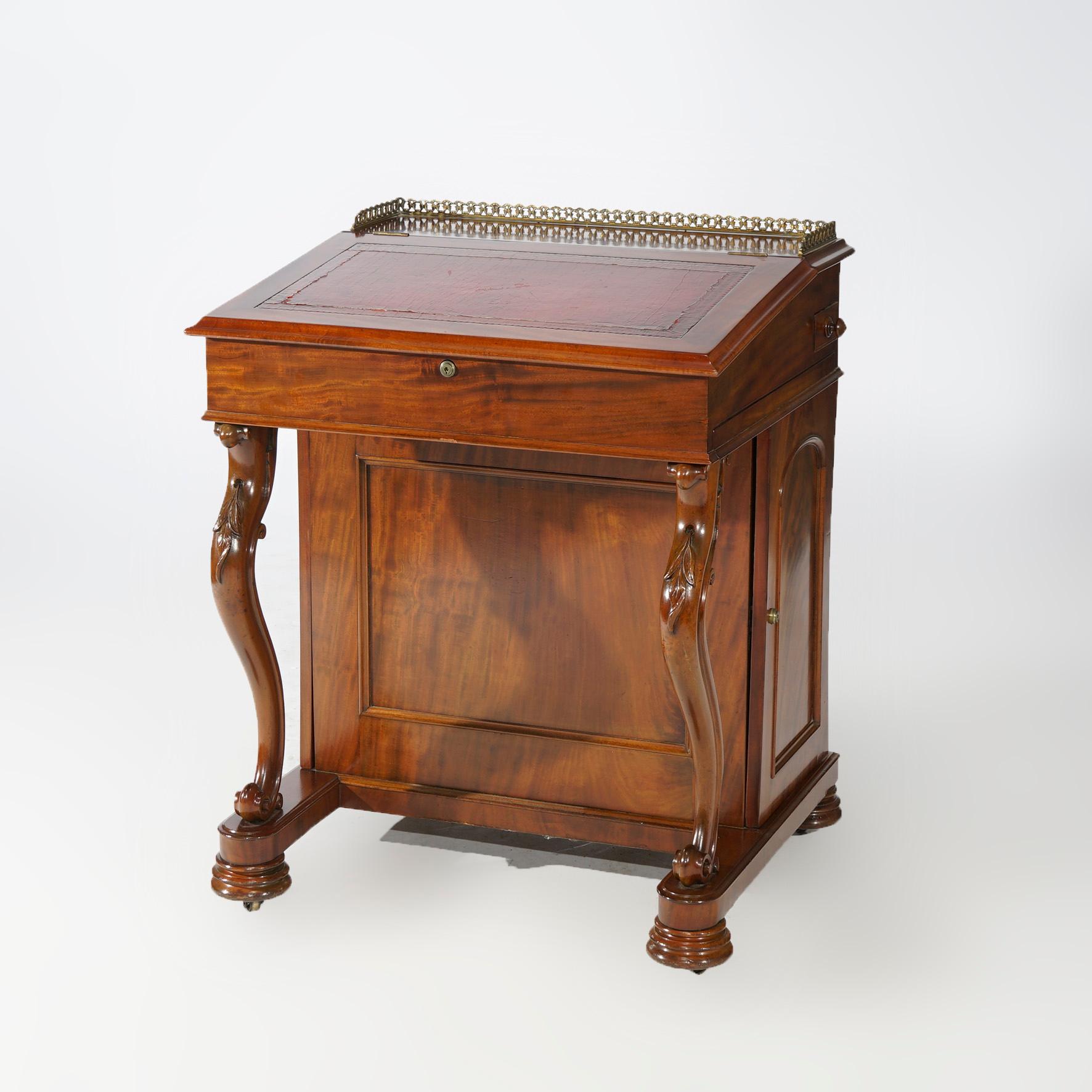Antique Davenport desk offers mahogany construction with upper having pierced gallery, slant front writing surface opening to interior compartment surmounting case with side cabinets and drawers with forward scroll form supports, c1890

Measures-