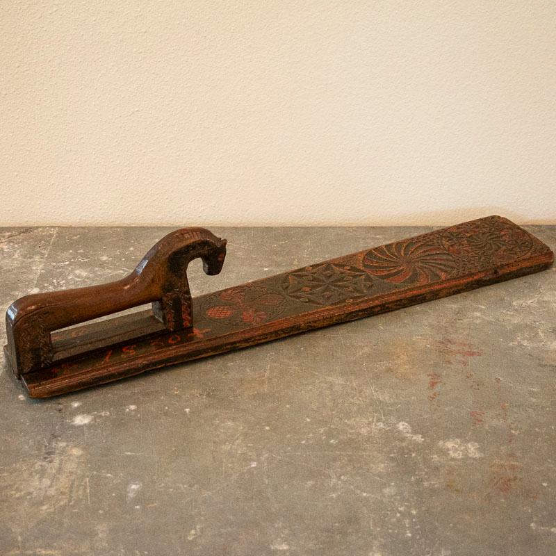 This mangle board shows off the craftsman's skill in the wonderful carved spheres and traditional horse. The original green and red paint have faded through use and time, but accent the carving beautifully. Notice the monogram and date of 1830