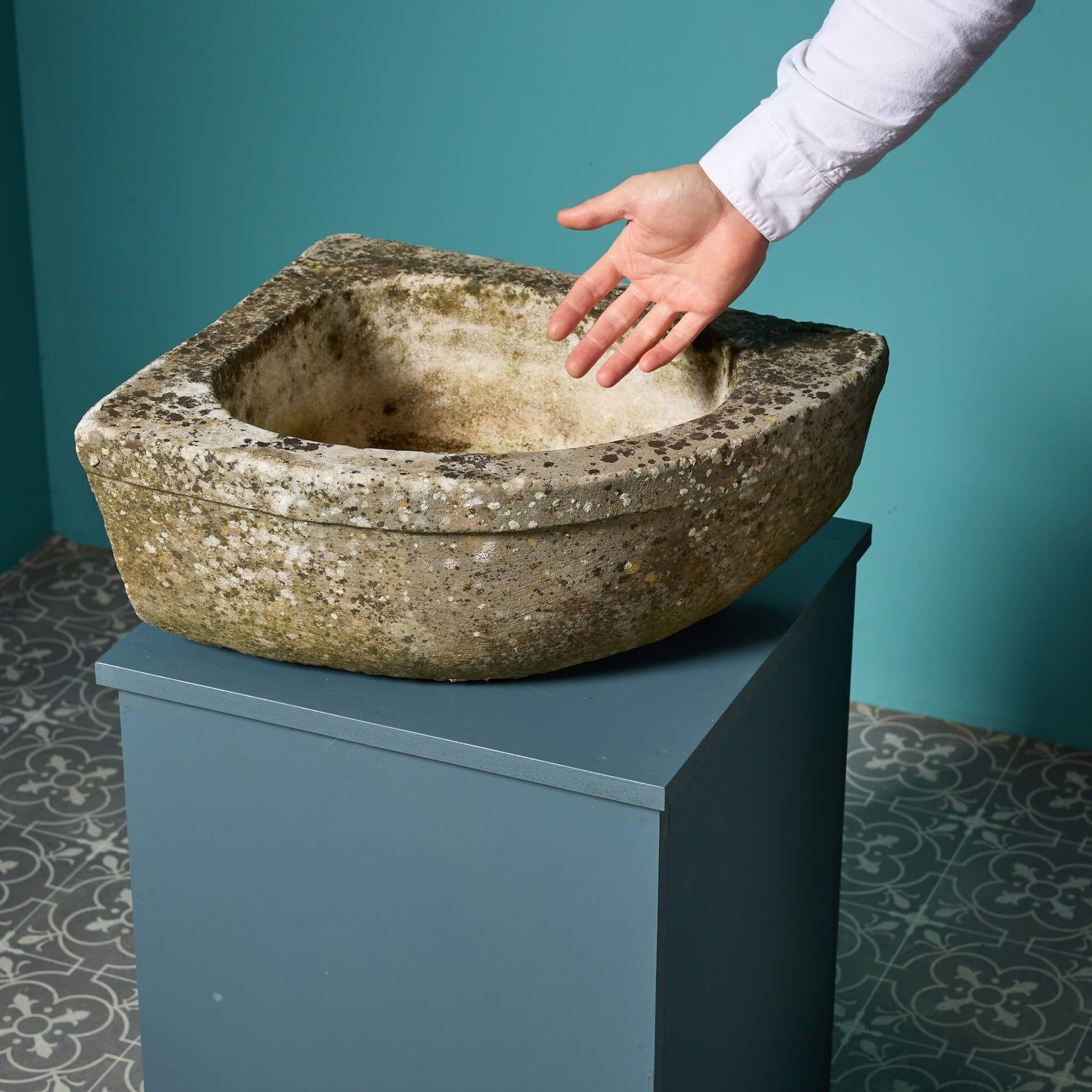 An antique carved marble corner basin with a bow shaped front.

Dating to the 18th century, this charming trough has certainly stood the test of home, showcasing a desirable weathered finish creating a characterful rustic country look.

This piece