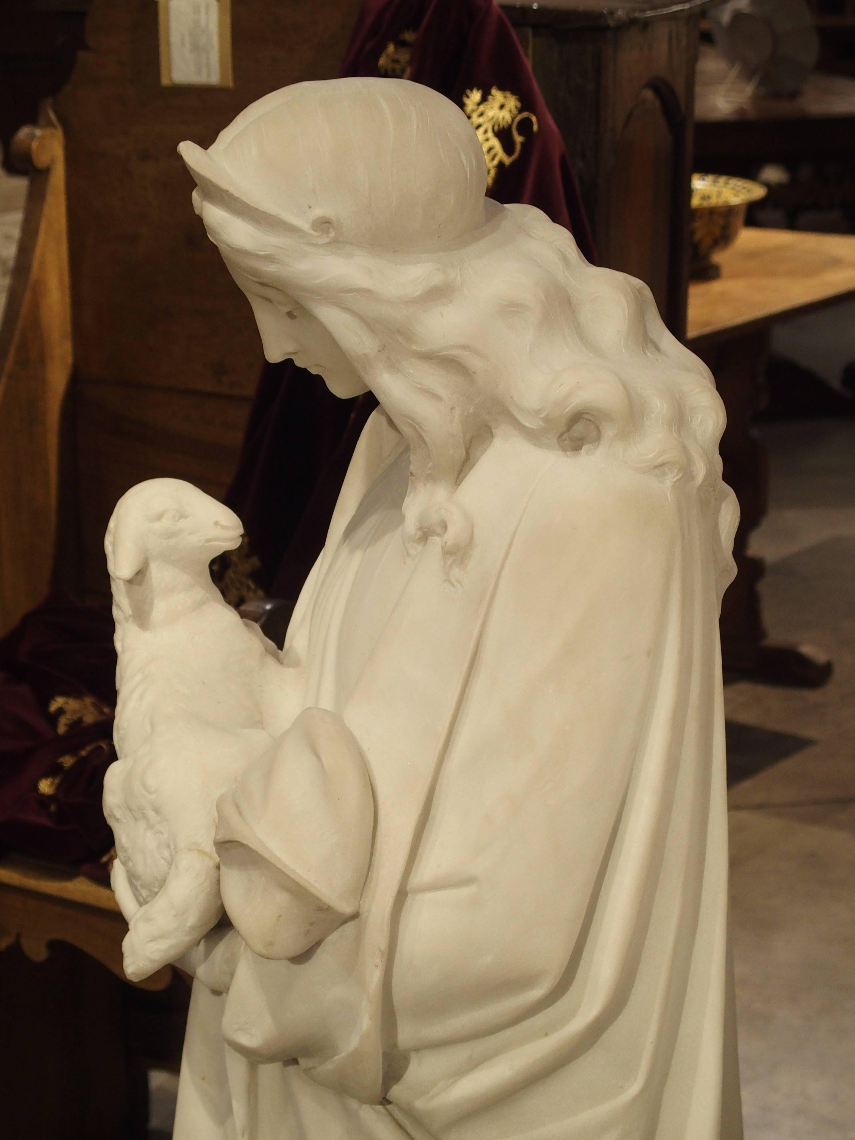 This is a beautiful marble statue of St. Agnes, also called St. Agnes of Rome, tenderly holding a lamb, is the symbol of purity. The statue dates to the end of 19th century or early 1900s and was carved by Daprato Rigali. St. Agnes wears a headdress