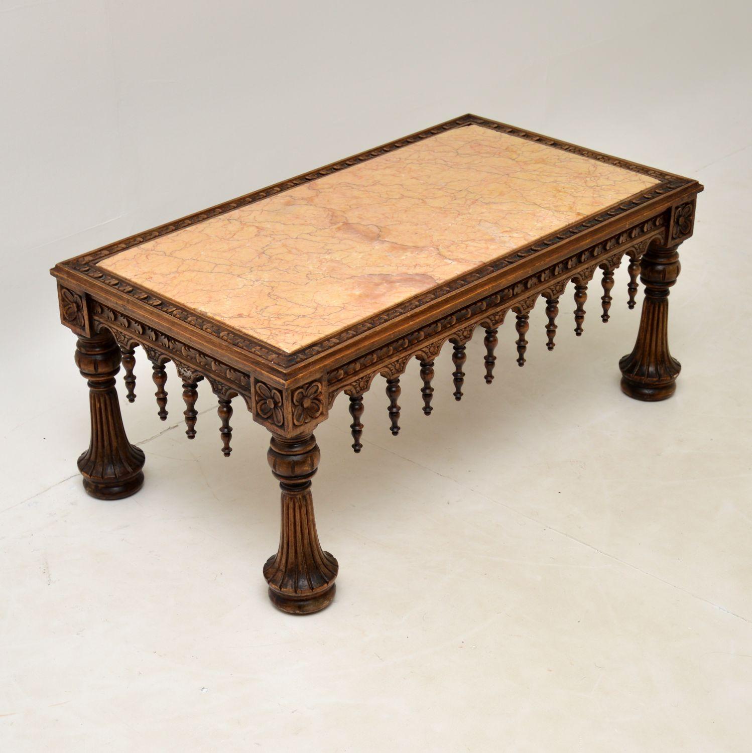 A beautifully striking antique marble top coffee table, which I would date to around the 1890-1910 period. It has a Moorish influence and was possibly made in Spain or it could be Colonial.

The frame is spectacularly carved from solid oak or