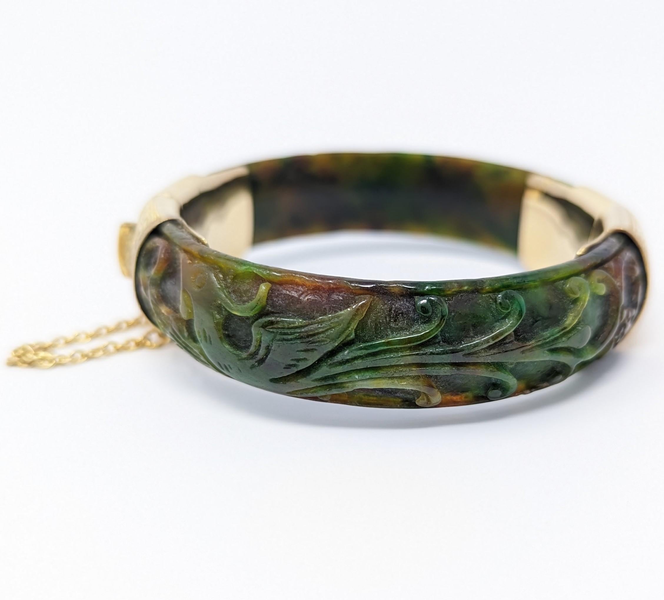 Gorgeous vintage to antique hand carved nephrite jade bracelet. Accentuated with 14k solid yellow gold, this enchanting piece features what looks to be a phoenix on one side and a dragon on the other side. Hallmarked 