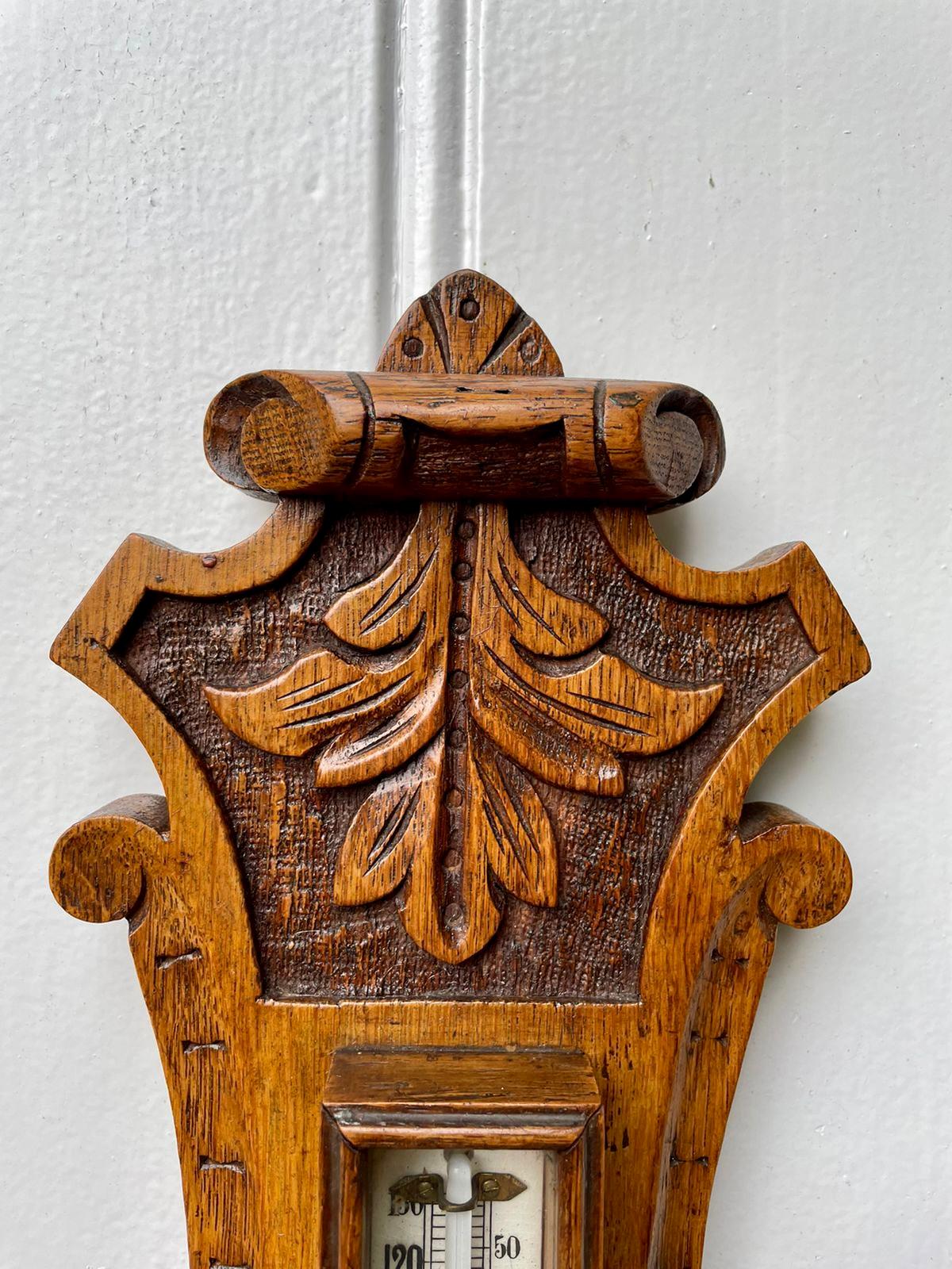 Antique carved oak banjo barometer having a quality carved oak case with scrolls and leaf decoration with original brass bezel, porcelain dial and a thermometer.

In original condition and in good working order.

Measures: H 64cm 
W 19cm 
D