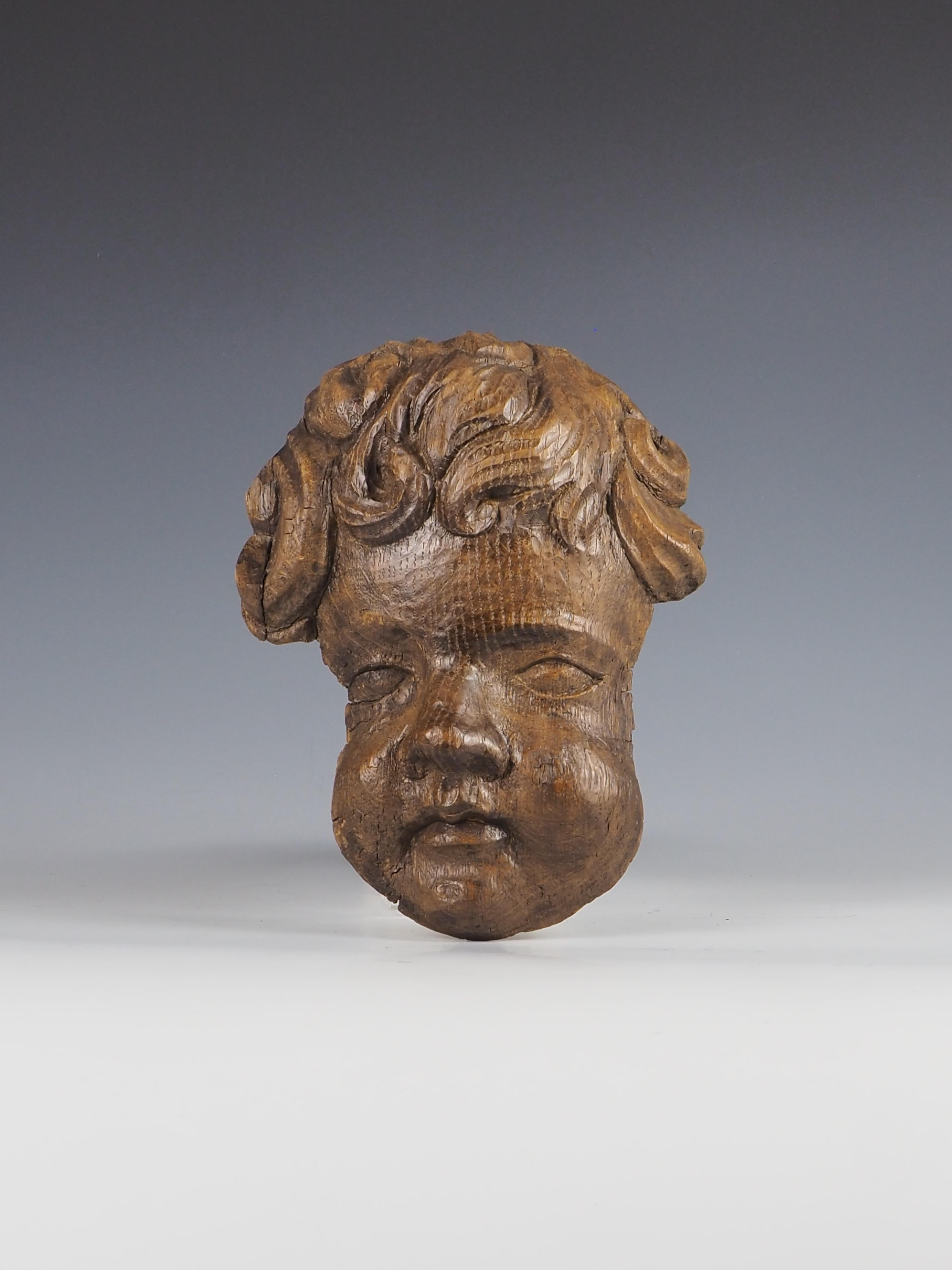 Lo squisito appendiabiti da parete con testa di cherubino in legno di quercia intagliato è una splendida rappresentazione dell'artigianato di un'epoca passata, probabilmente parte di un insieme decorativo più ampio.

Il pezzo presenta un eccezionale