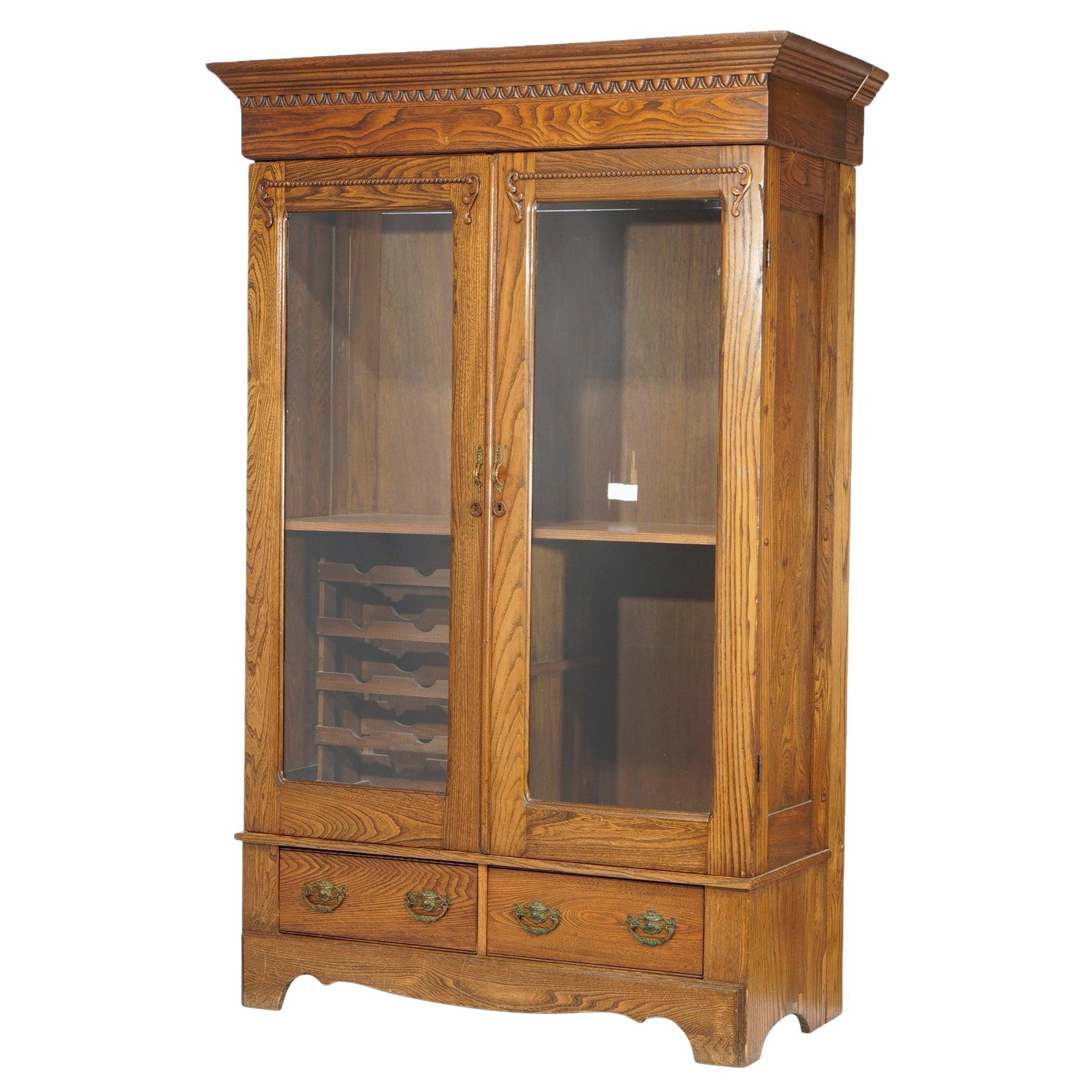 Antica libreria a due ante in Oak intagliata con portabottiglie c1920