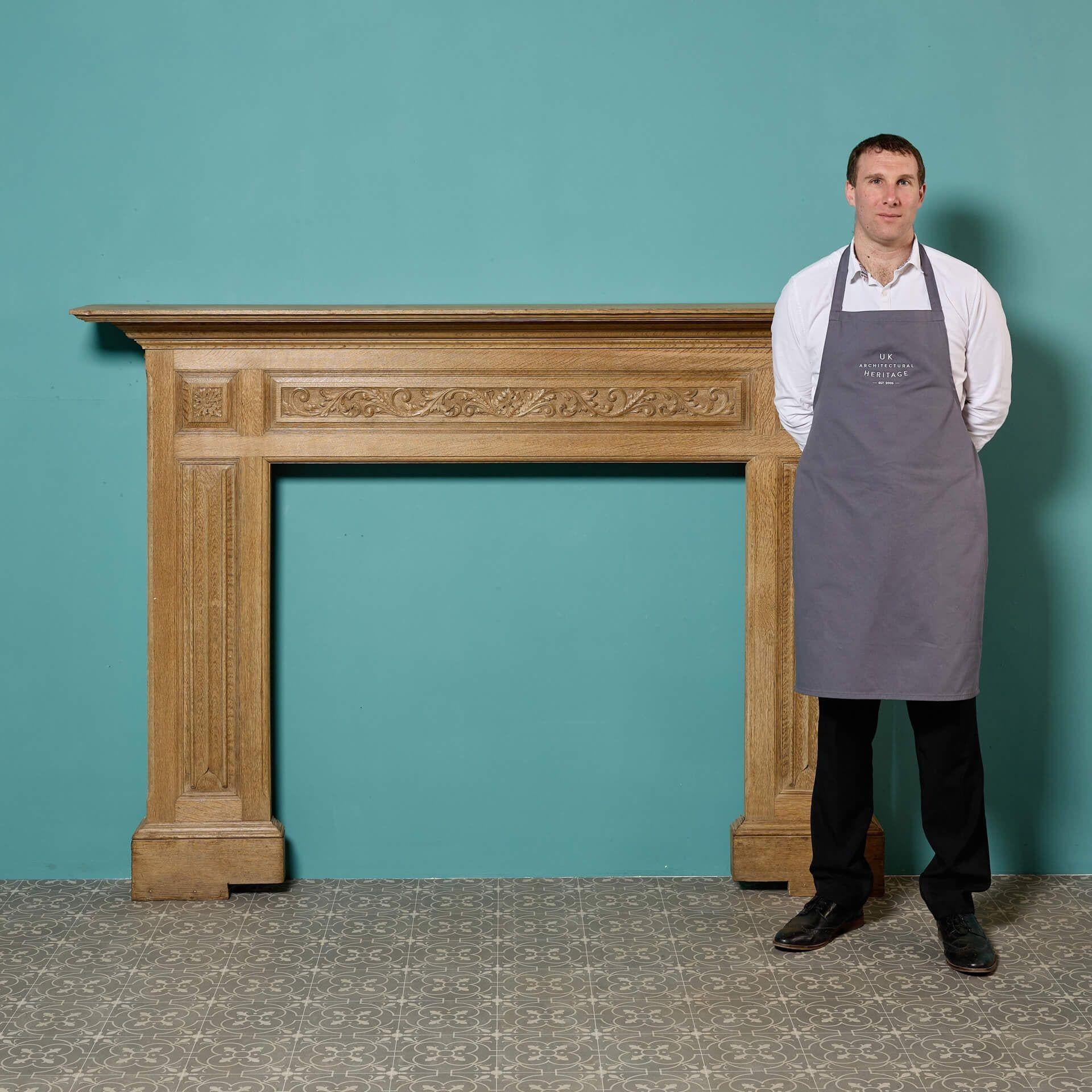 A large antique English carved oak fireplace surround, circa 1880. With its light oak colour and simple styling, this antique fire surround is a handsome addition to interiors traditional and contemporary alike. Features include a frieze panel