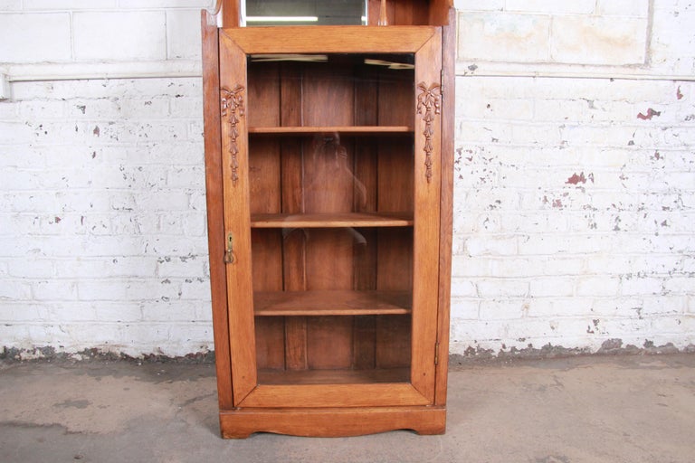 Antique Carved Oak Glass Front Bookcase with Beveled Mirror, circa 1900