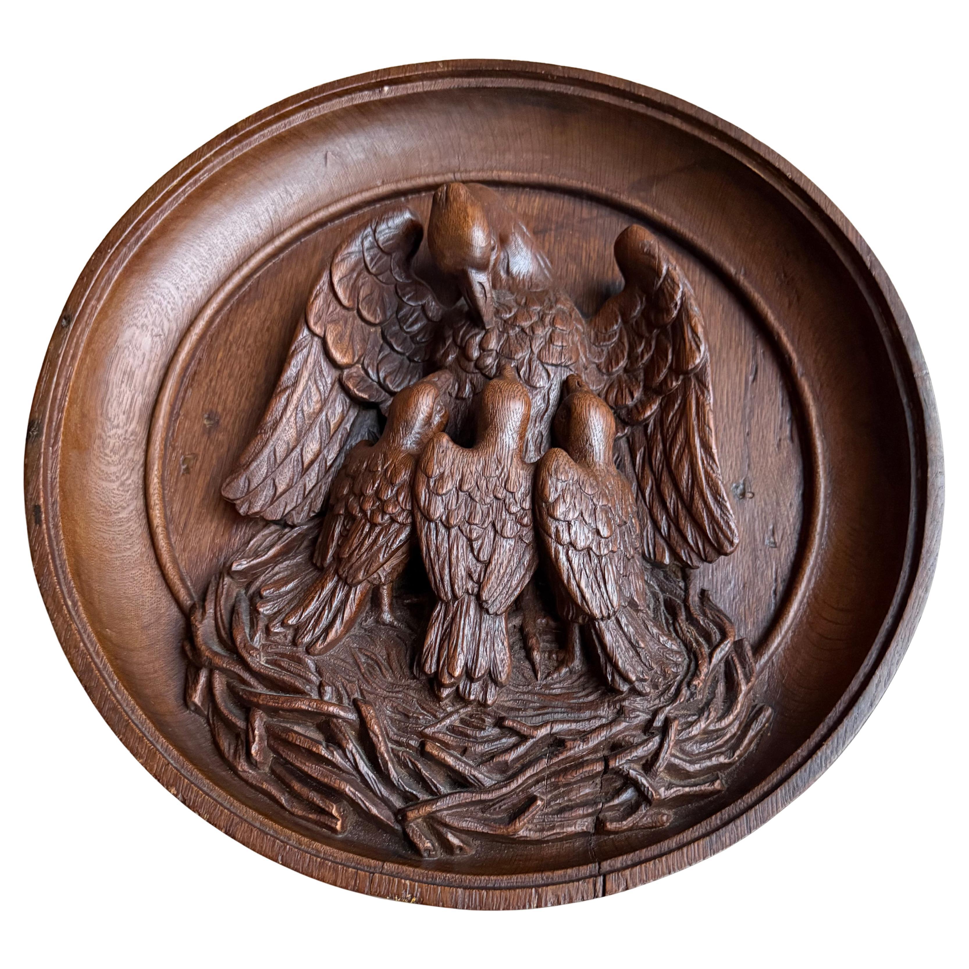 All hand carved, quality workmanship and symbolic wall panel in thick relief with high border.

The character ascribed to the pelican in this context is nearly as fabulous as that of the phœnix. From a clumsy, gluttonous, piscivorous water-bird, it