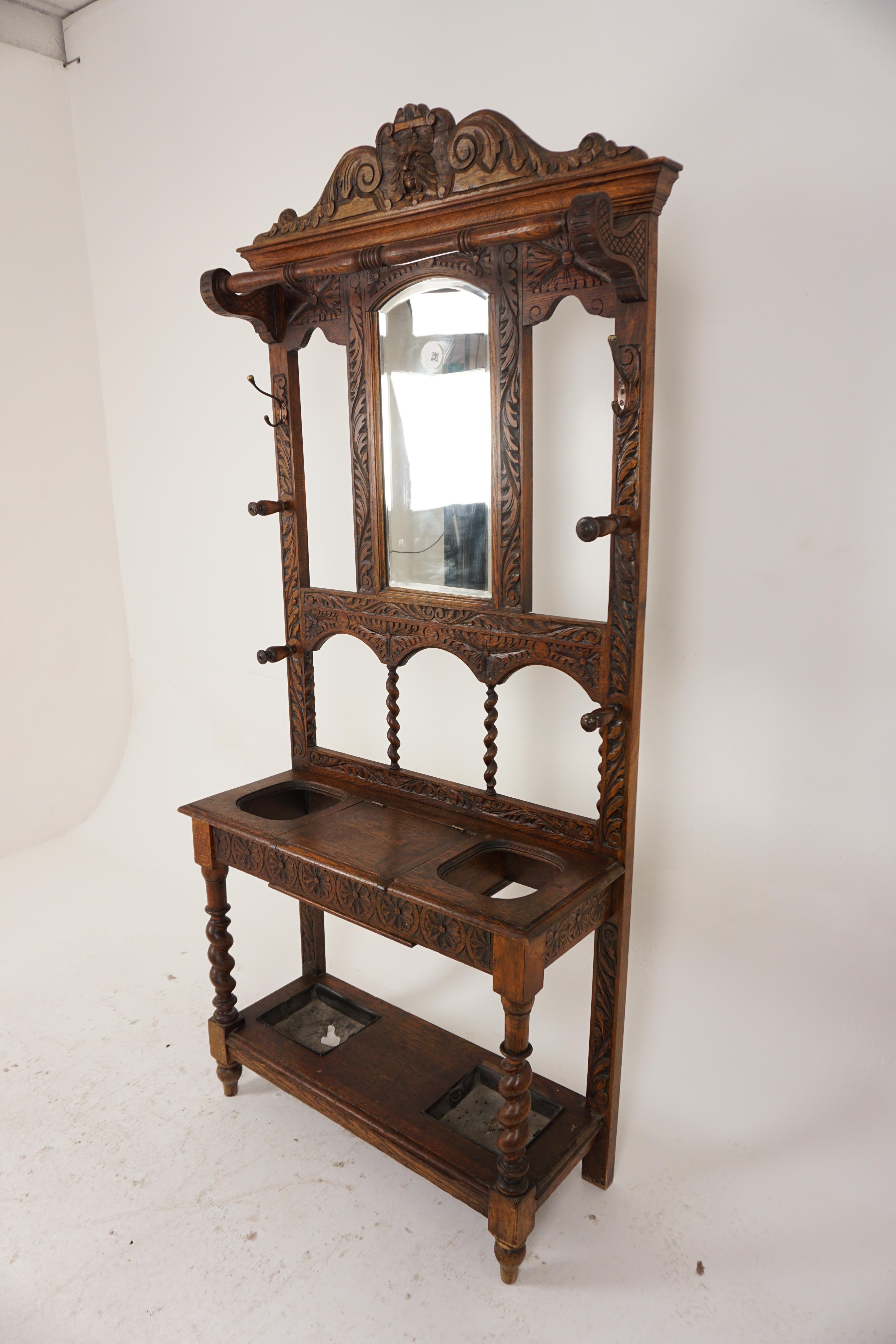 Antique Carved Oak Green Man Gothic Hall Stand Coat Rack, Scotland 1870, H1006 

Solid Oak
Original Finish
Carved green man pediment on cornice
Shaped bevelled mirror below
Carved back and supports on the ends with two brass hooks and four turned