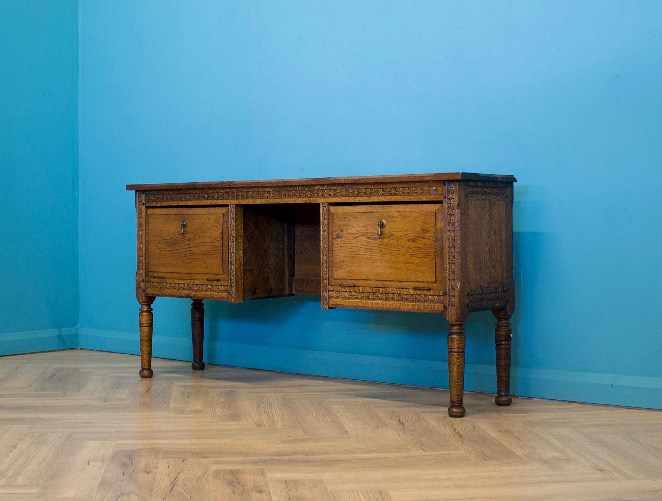 This beautifully carved 19th-century oak side table features two pull-down cupboards, each with two drawers.