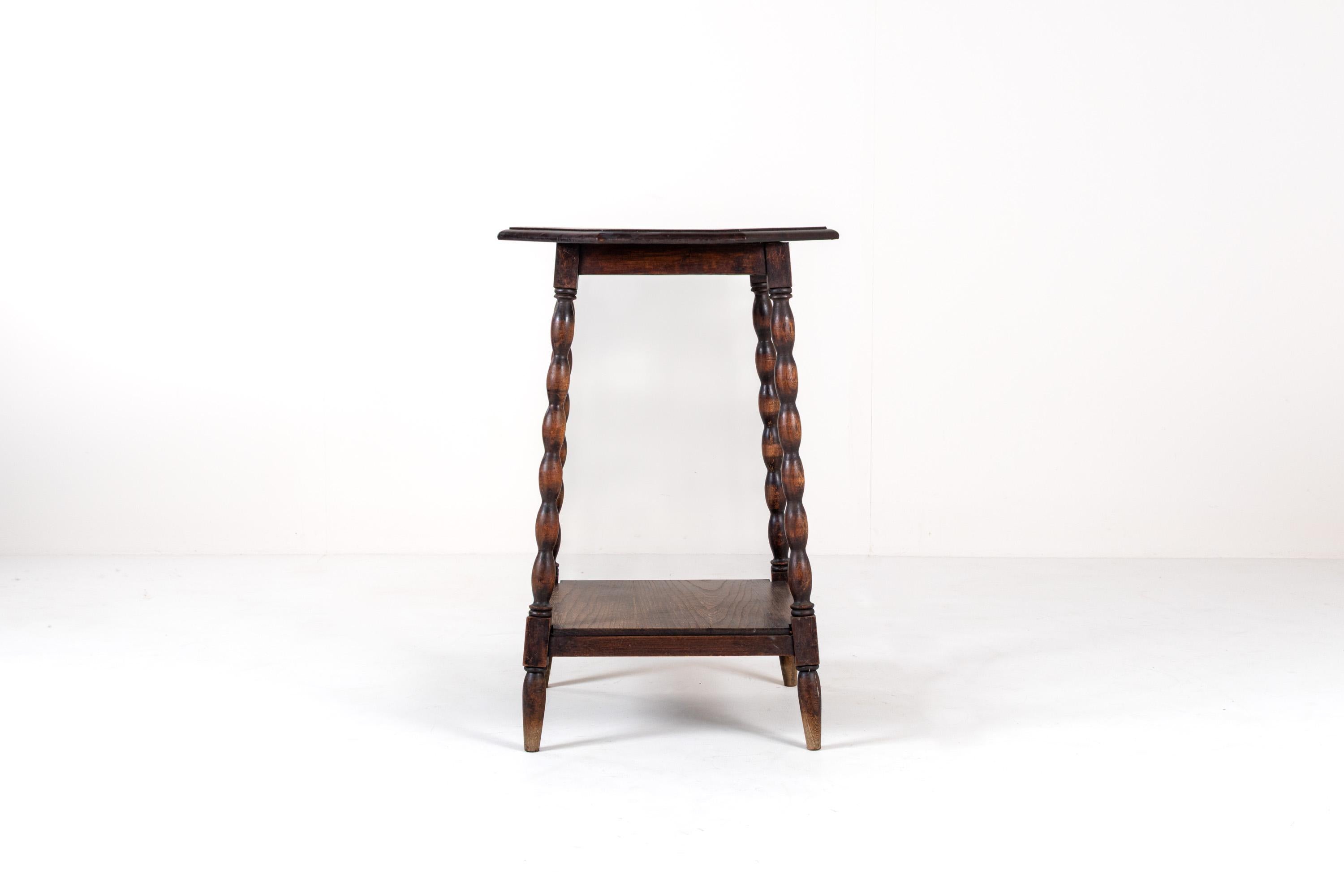 Charmante table d'appoint ancienne en chêne massif, dotée d'un plateau octogonal distinctif avec une bordure décorative sculptée à la main et d'élégants pieds torsadés en orge.
Bel exemple de l'artisanat du début du XXe siècle, cette table incarne