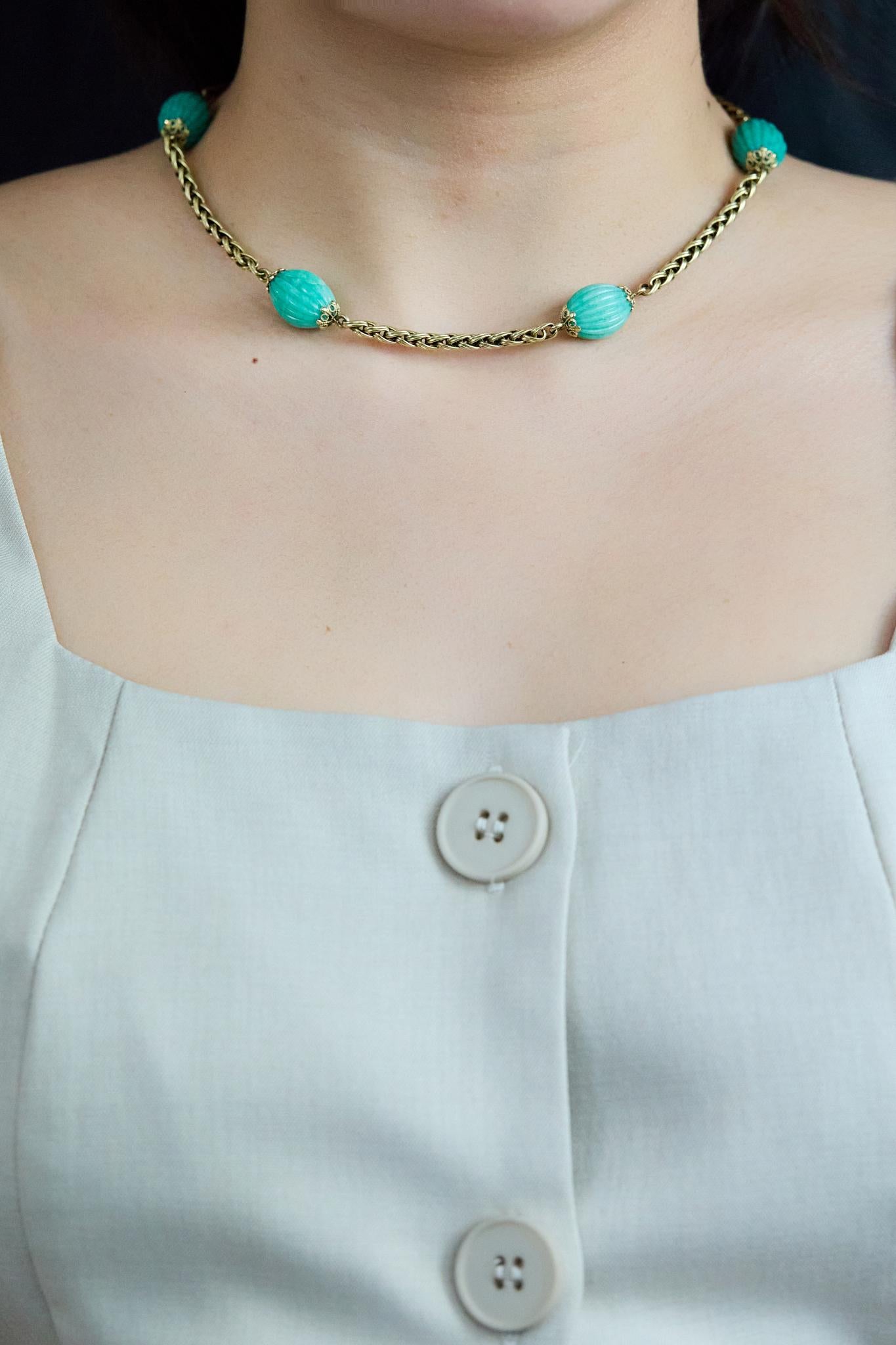 Magnifique collier de mode antique, composé de cinq turquoises ovales sculptées, disposées en station le long d'une chaîne tressée en or jaune 14k. Chaque pierre est complétée par des embouts complexes de style ancien. Cette pièce mesure 15,25