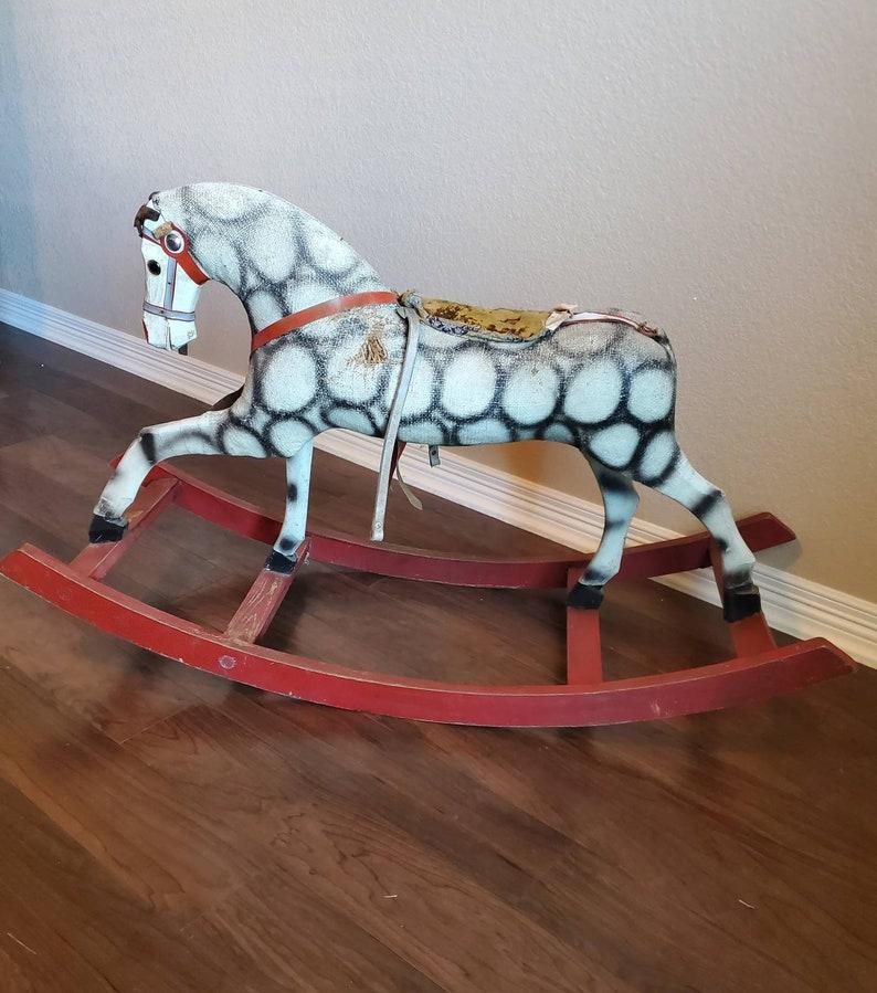 A charming and whimsical hand carved and painted wooden and fur fabric rocking horse with untouched, unrestored, elegantly aged patina. 

Very unique pattern and beautiful complimentary coloring. Circa 1900.

Dimensions (approx):
25